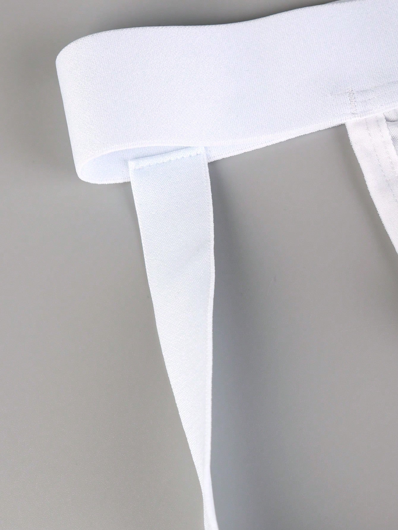Men's white plain daily G-string underwear with tape detail, mid-rise fit, and minimal jockstrap-style design