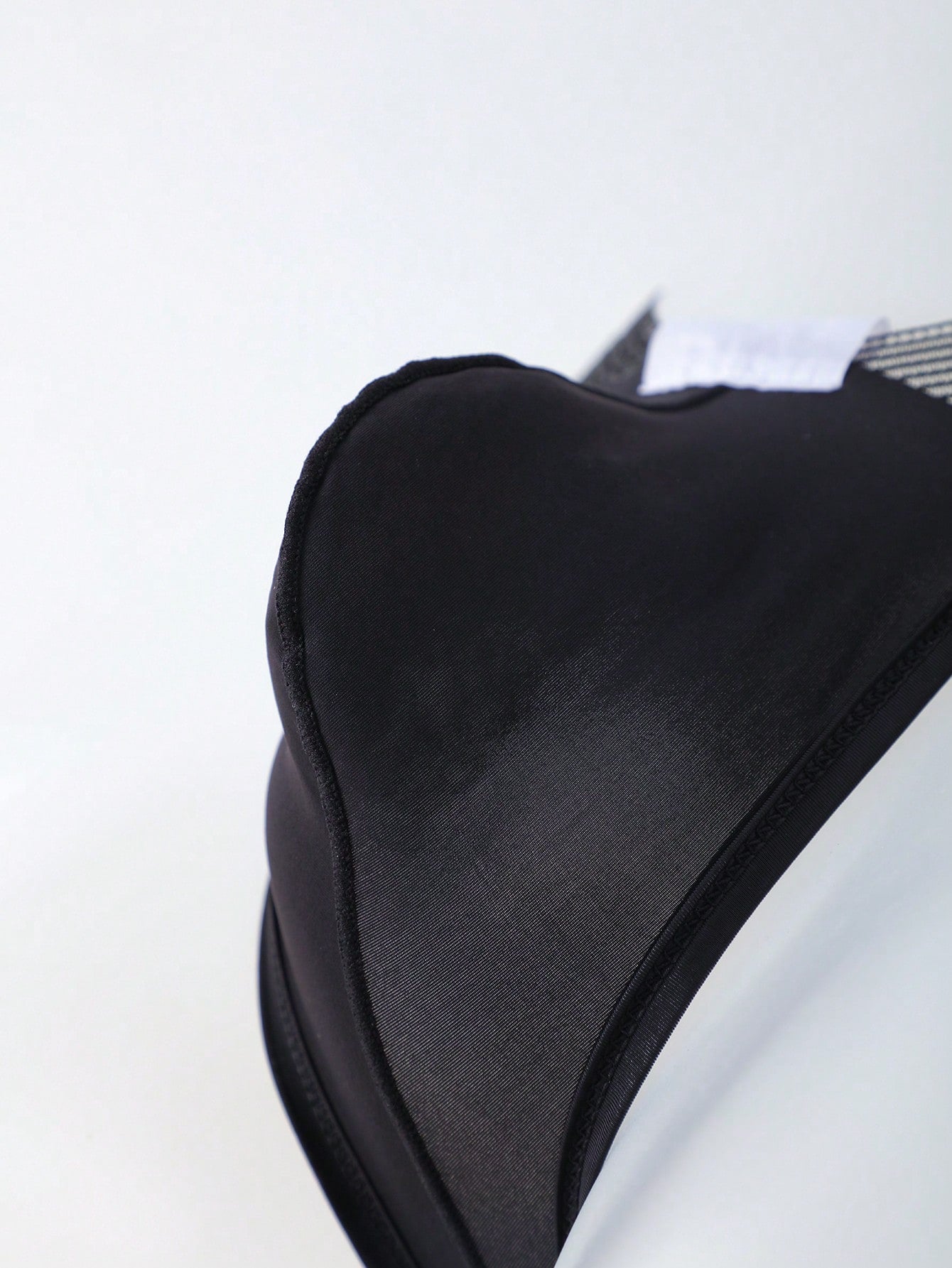 Men's black low-rise mesh T-back thong briefs with colorblock pattern and patched details