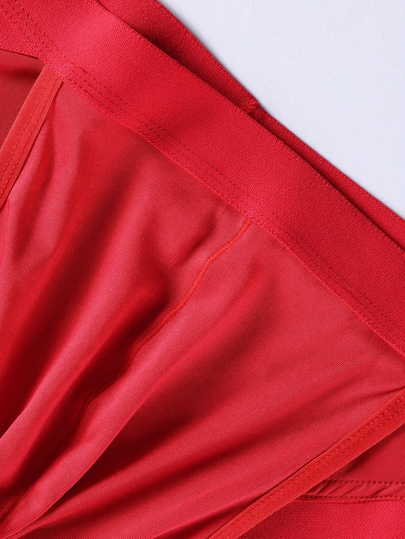 Men's red low-rise thong with lace panel, cut-out detail, and colorblock design
