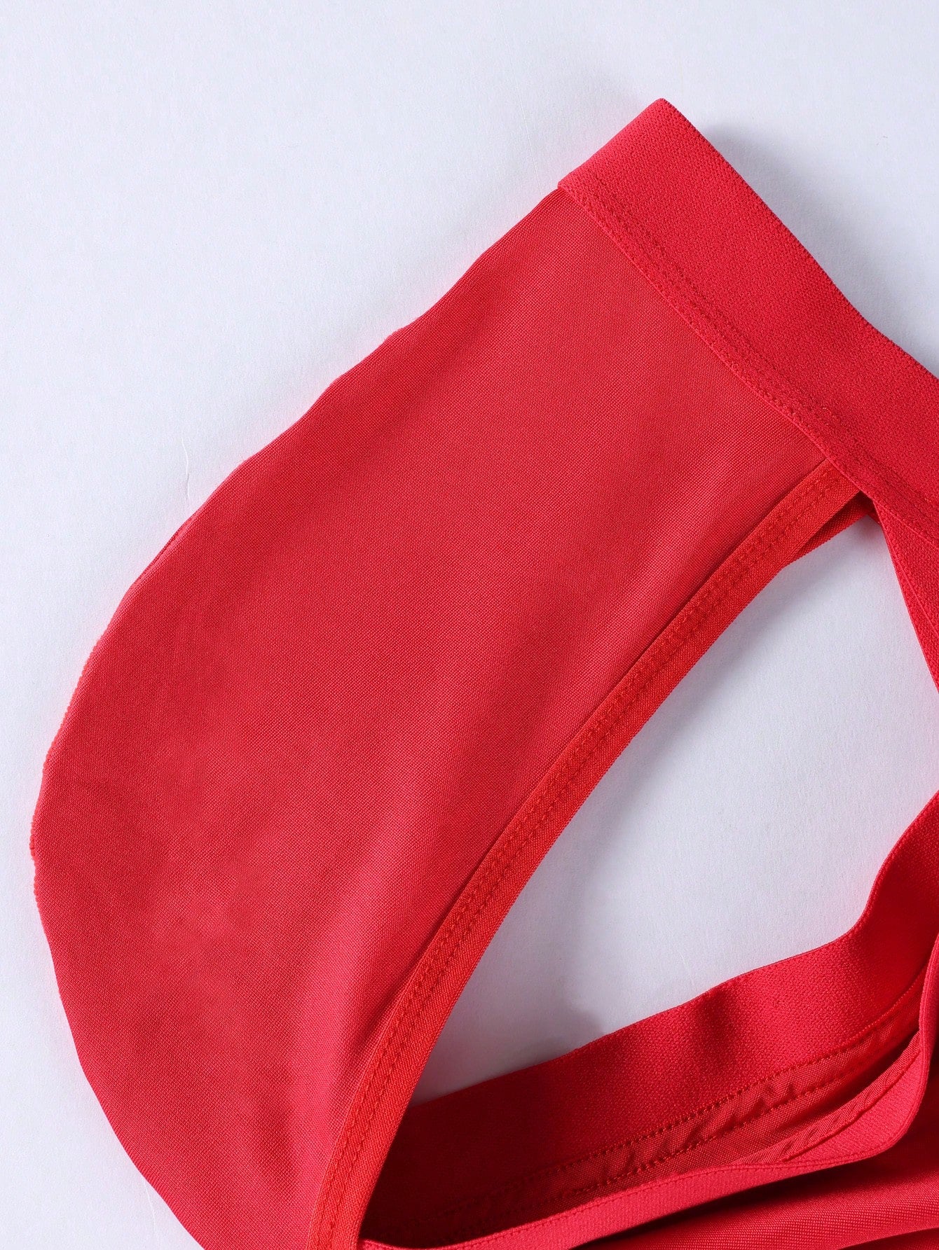 Men's red low-rise thong with lace panel, cut-out detail, and colorblock design