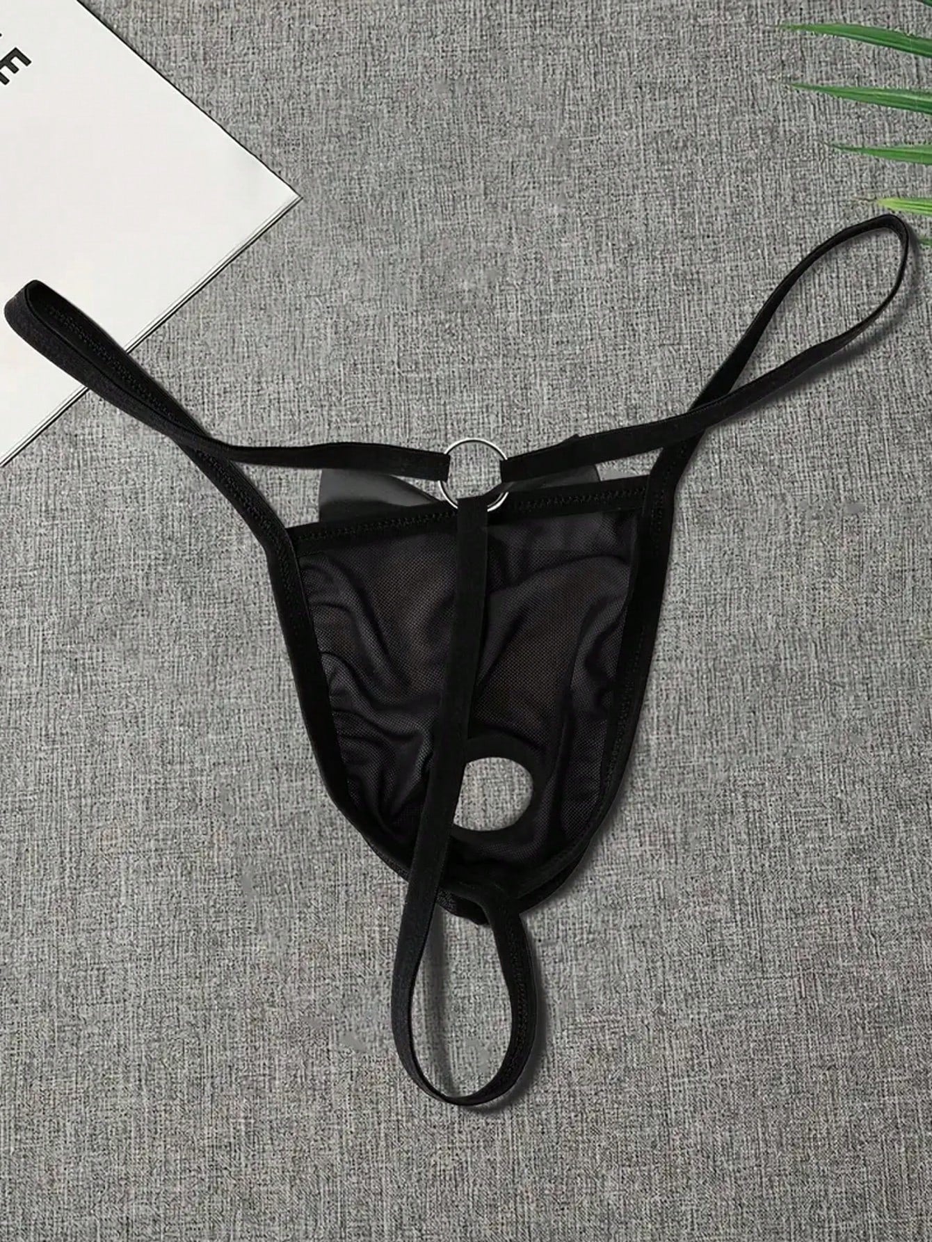 Men's black sheer mesh thong underwear with Halloween bow print pattern, bow decor, and cut-out details