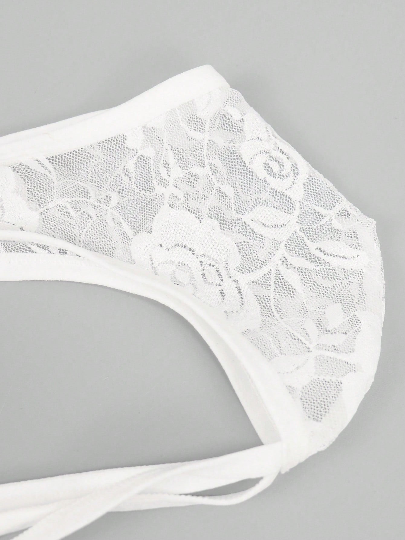 Men's black low-rise thong underwear with contrast rose lace trim and hollow-out back design