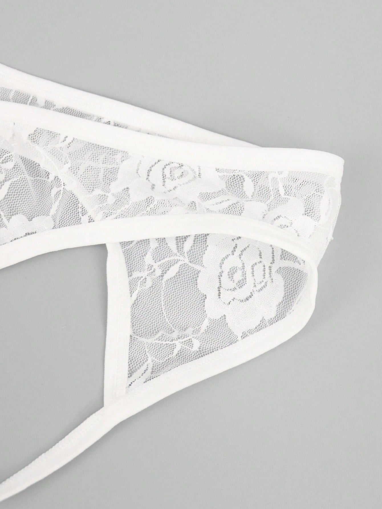 Men's black low-rise thong underwear with contrast rose lace trim and hollow-out back design