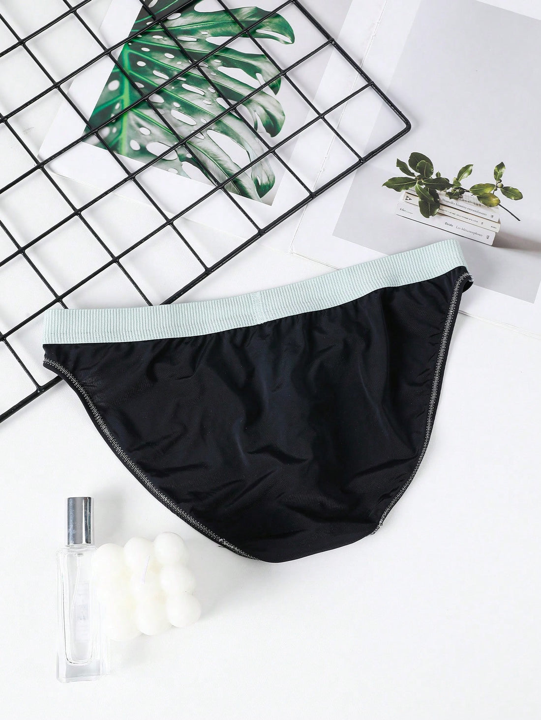 Men's low rise briefs with pouch, backless cut-out design, elastic waist, and contrast binding