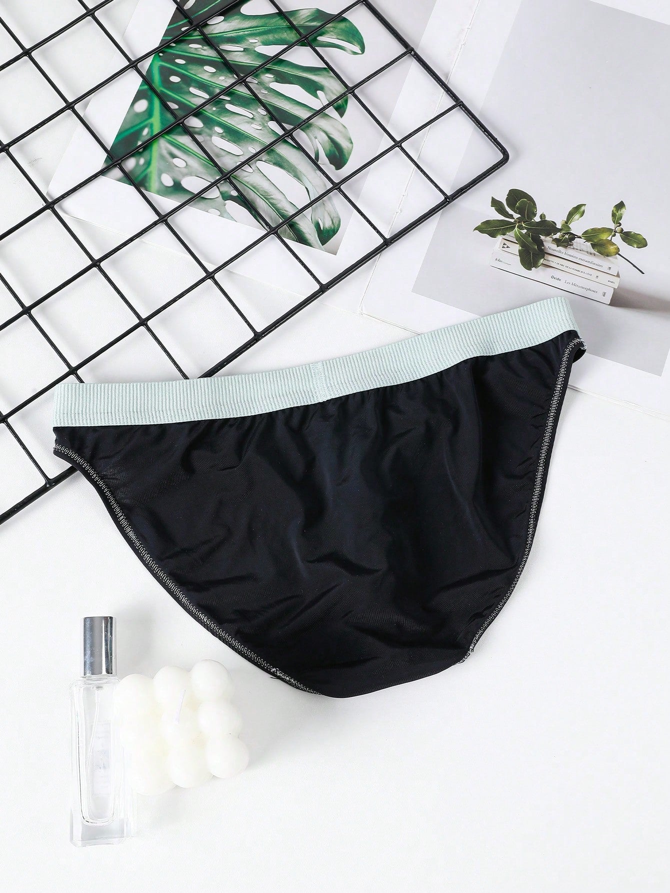 Men's low rise briefs with pouch, backless cut-out design, elastic waist, and contrast binding