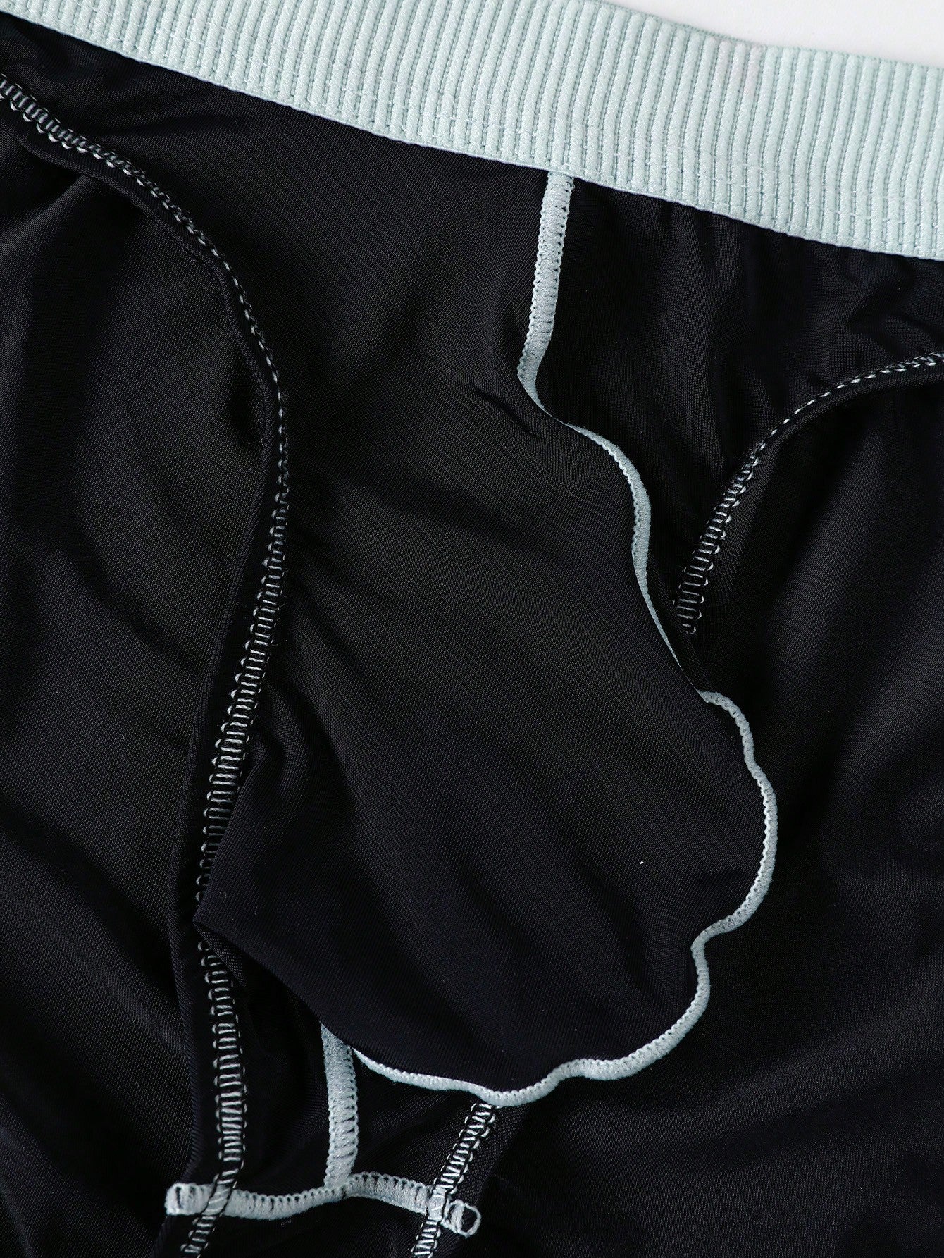 Men's low rise briefs with pouch, backless cut-out design, elastic waist, and contrast binding