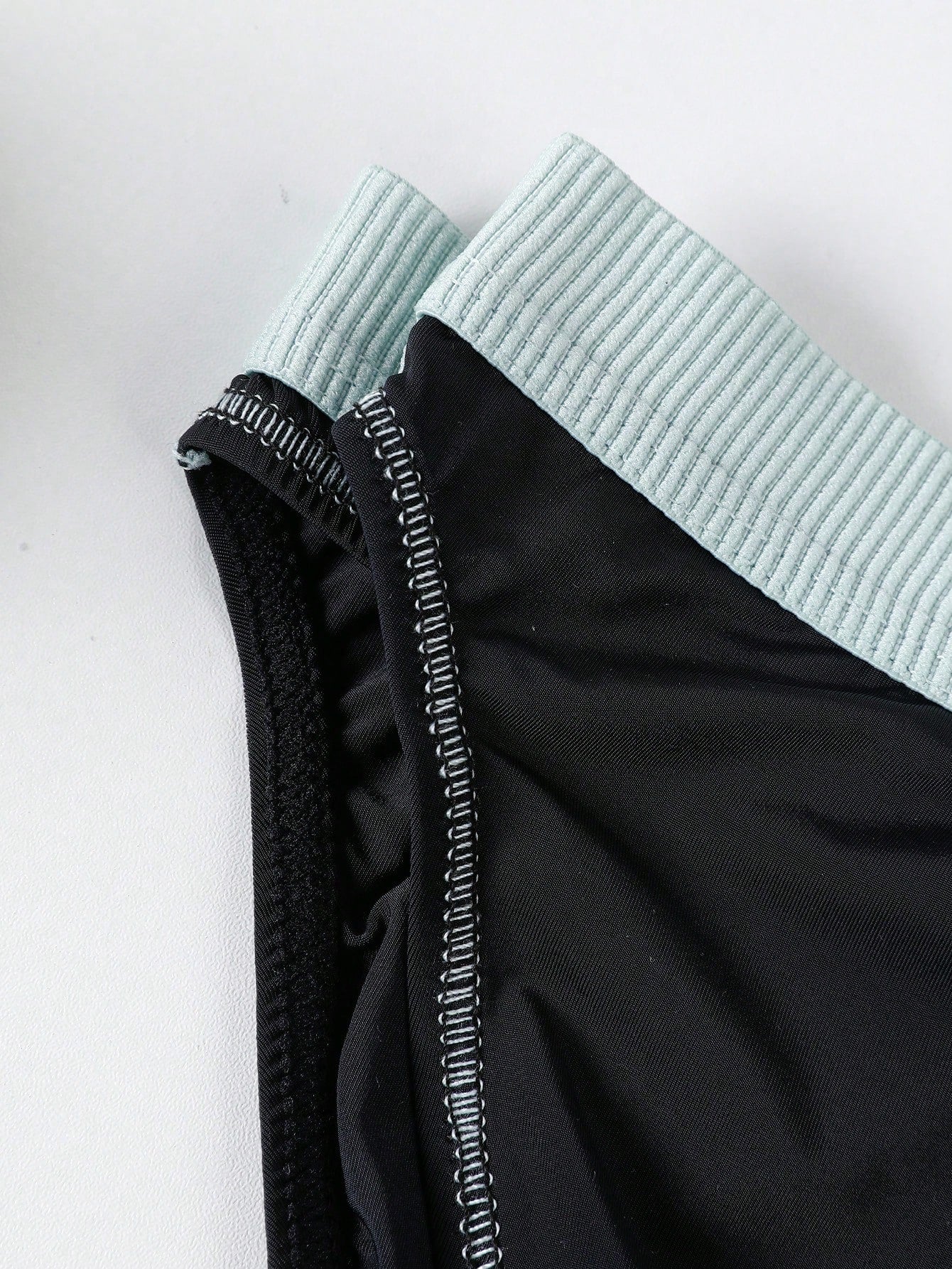 Men's low rise briefs with pouch, backless cut-out design, elastic waist, and contrast binding