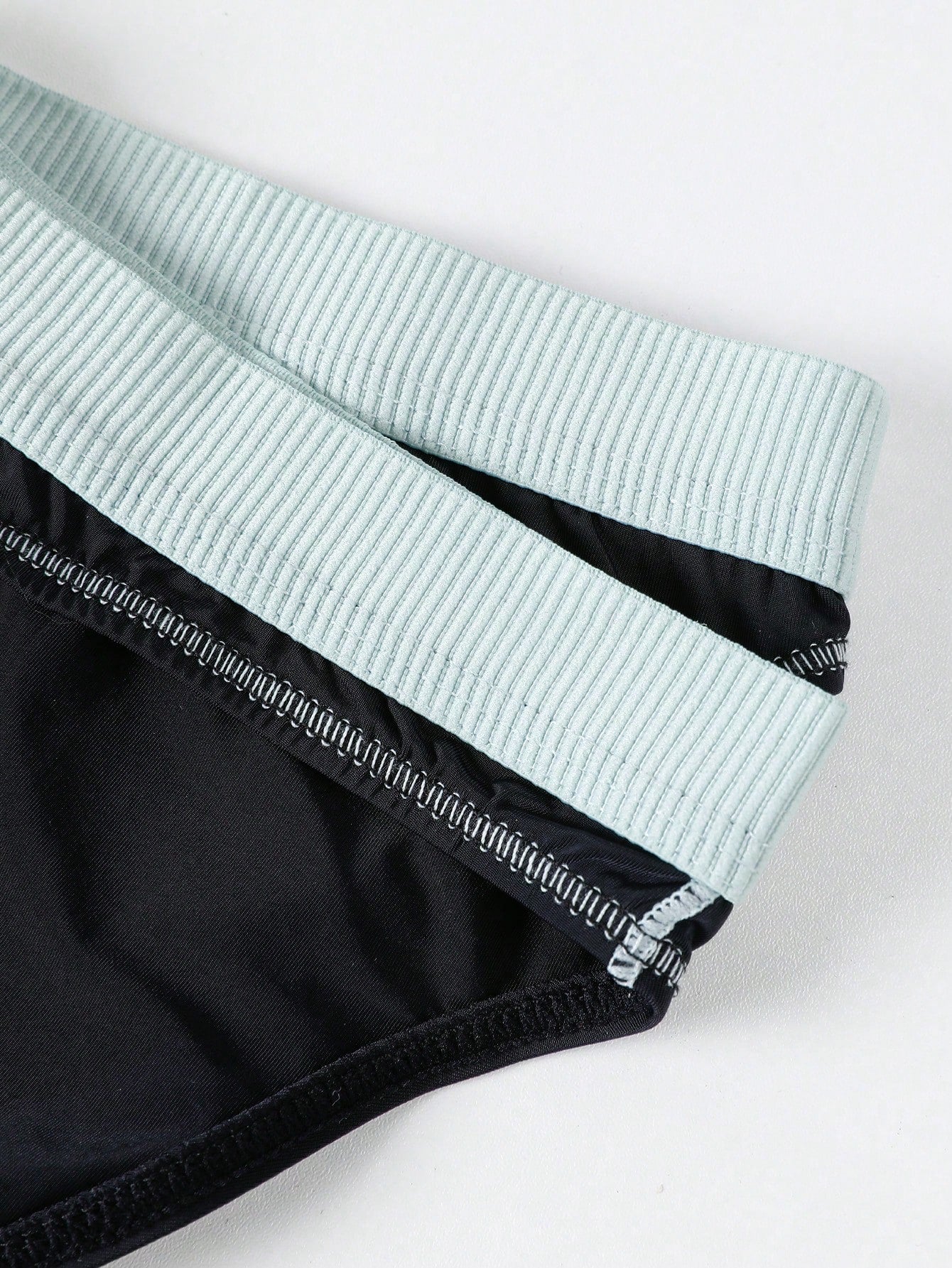 Men's low rise briefs with pouch, backless cut-out design, elastic waist, and contrast binding