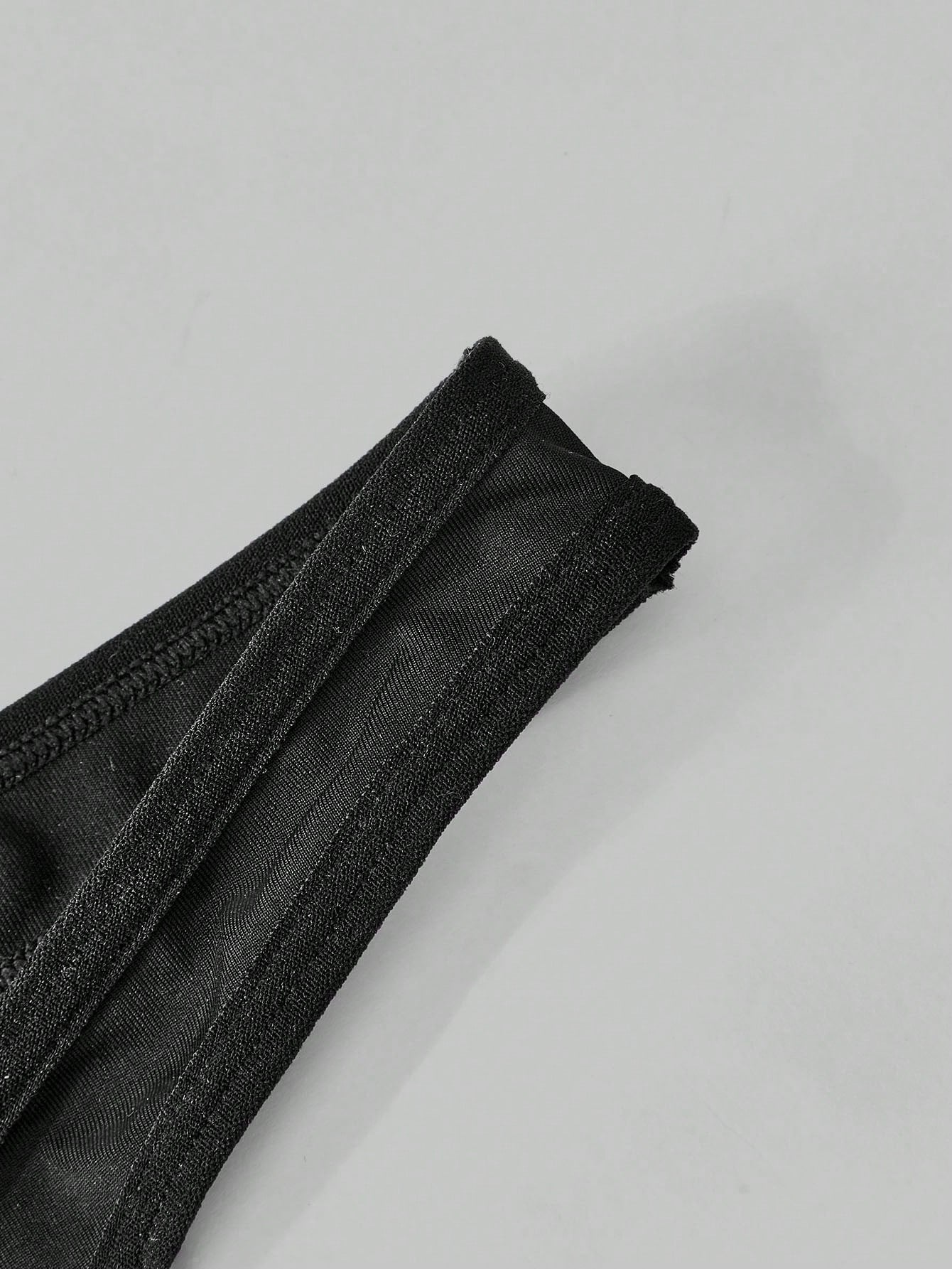 Men's black lace low-rise thong underwear in a plain unlined design