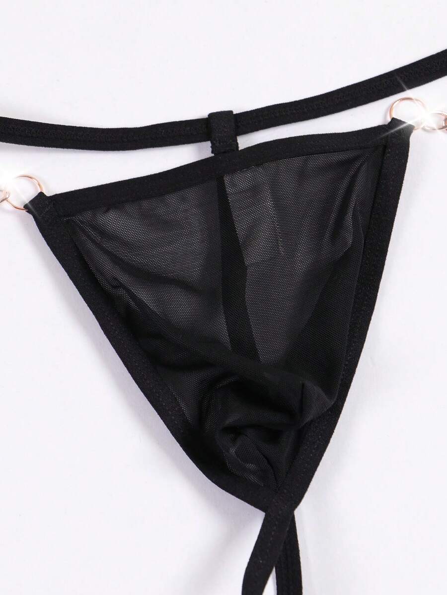 Black men's low rise thong underwear featuring semi-sheer knitted fabric, cut out design, contrast binding, and metallic chain decor.