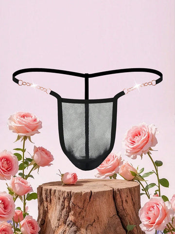 Black men's low rise thong underwear featuring semi-sheer knitted fabric, cut out design, contrast binding, and metallic chain decor.