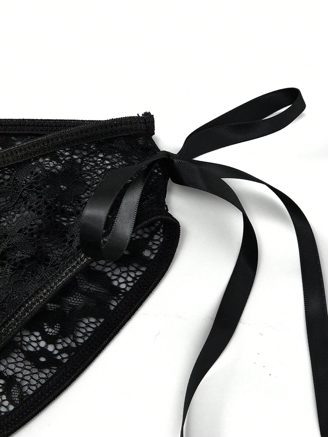 Men's black low-rise lace jockstrap thong underwear with hollow-out details and semi-sheer fabric