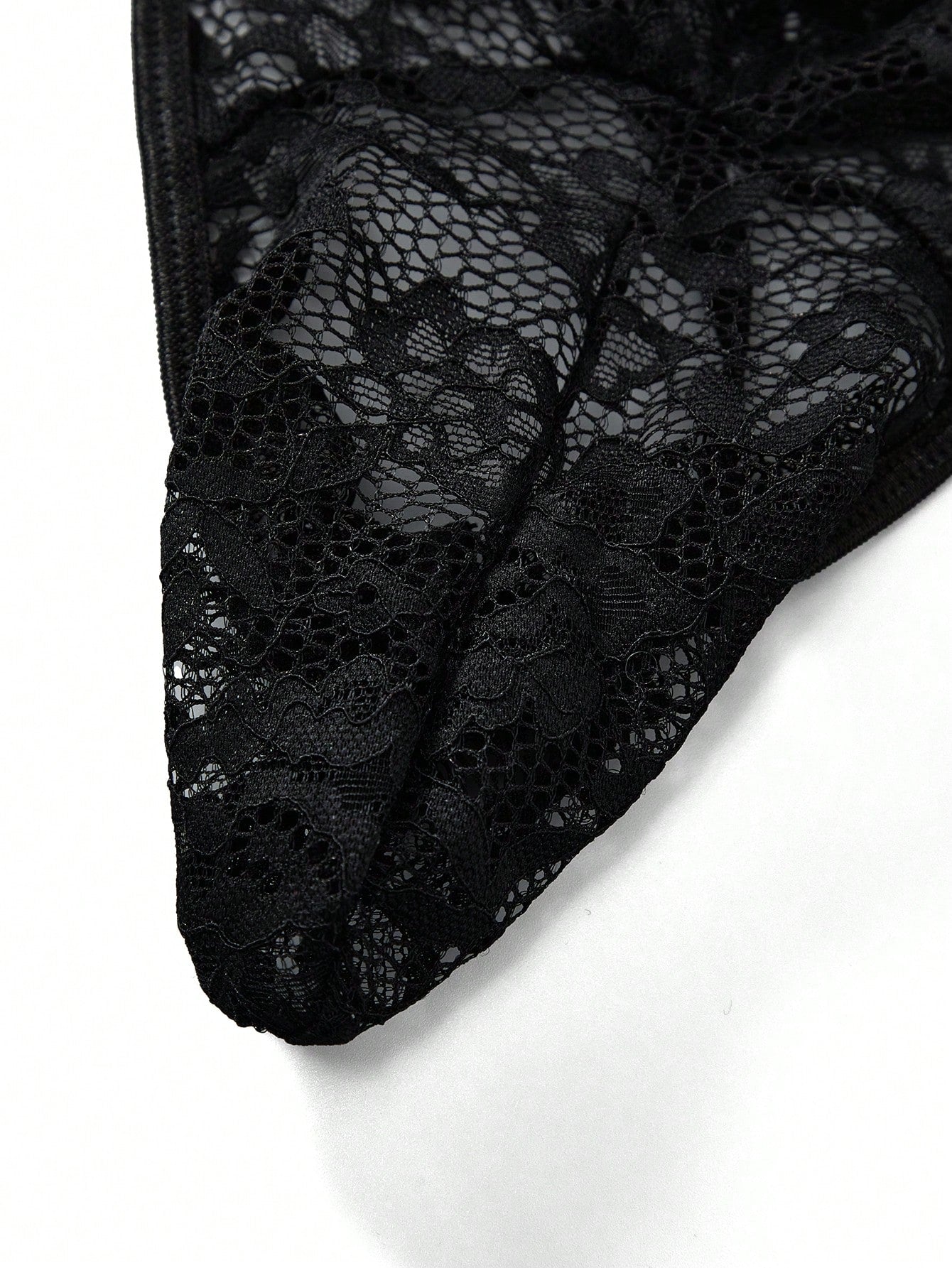 Men's black low-rise lace jockstrap thong underwear with hollow-out details and semi-sheer fabric