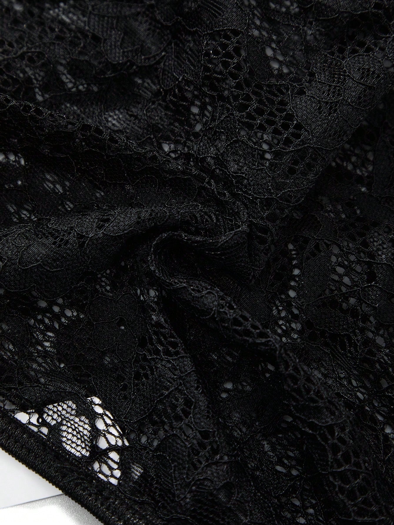 Men's black low-rise lace jockstrap thong underwear with hollow-out details and semi-sheer fabric