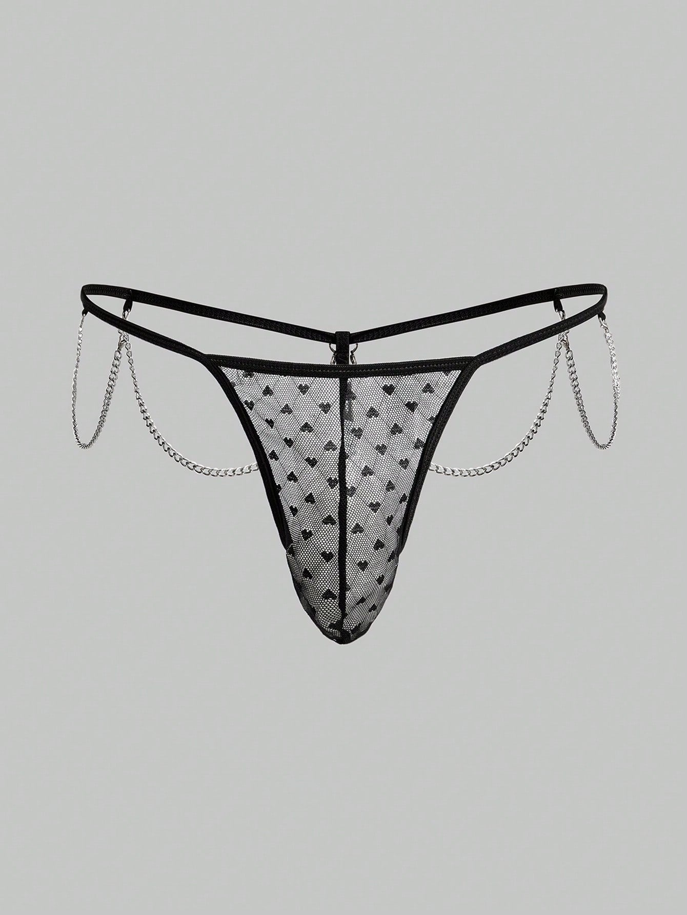 Men's black sheer mesh low-rise thong underwear with heart-shaped hollow-out design, geometric pattern, ring detail, and chain accent
