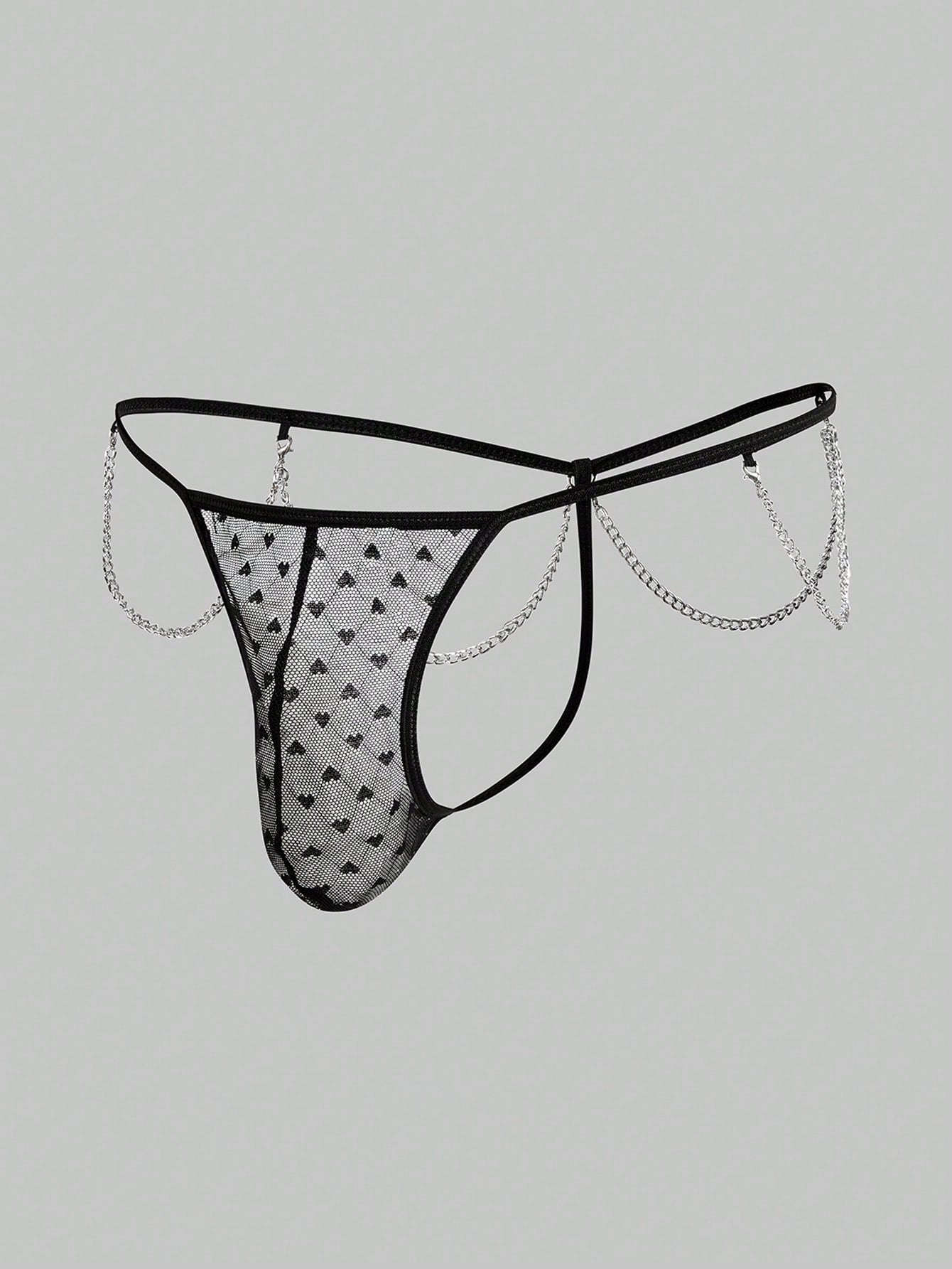 Men's black sheer mesh low-rise thong underwear with heart-shaped hollow-out design, geometric pattern, ring detail, and chain accent