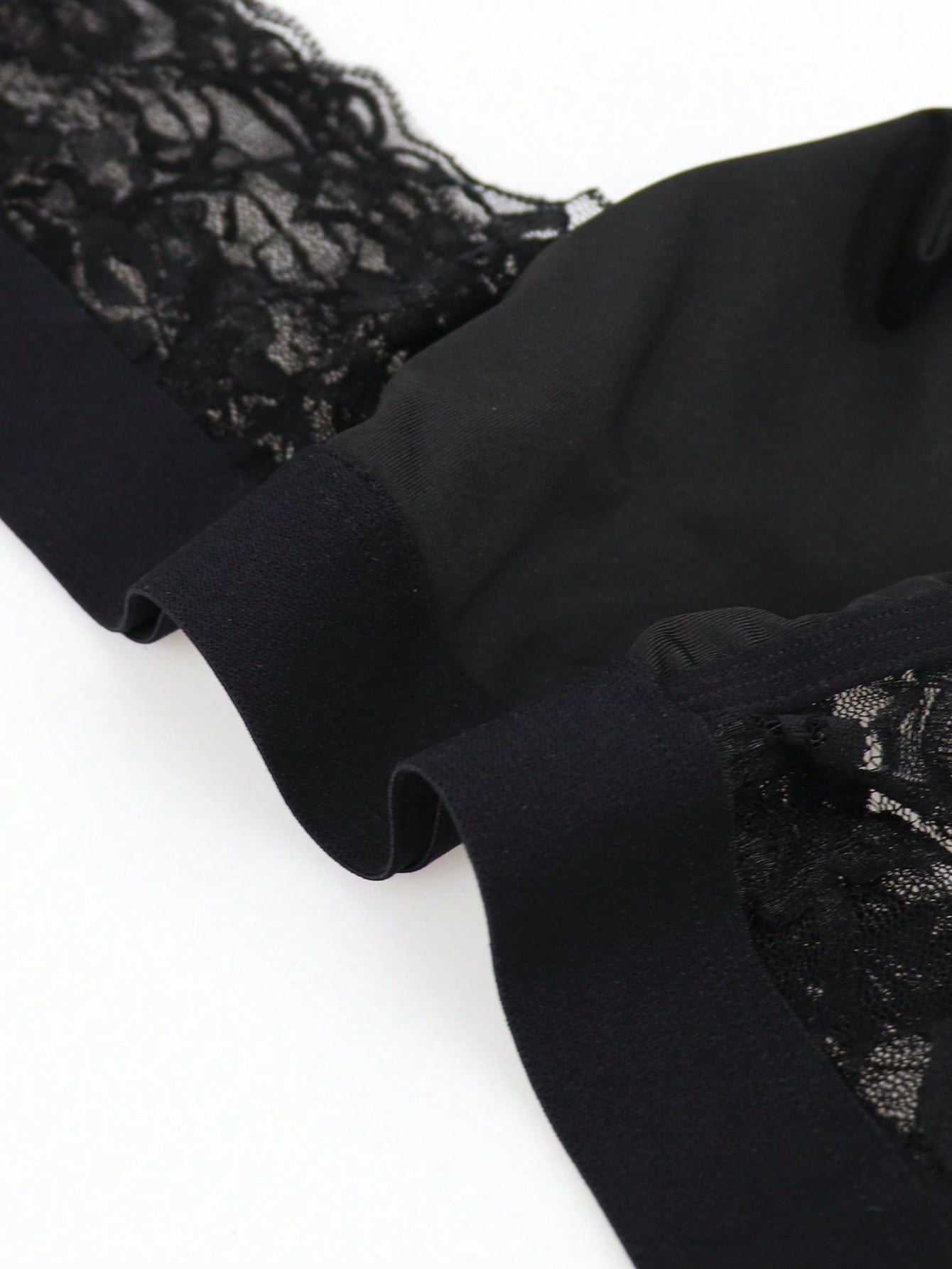Men's black lace wave thong briefs with plant pattern detail and mid-rise styling