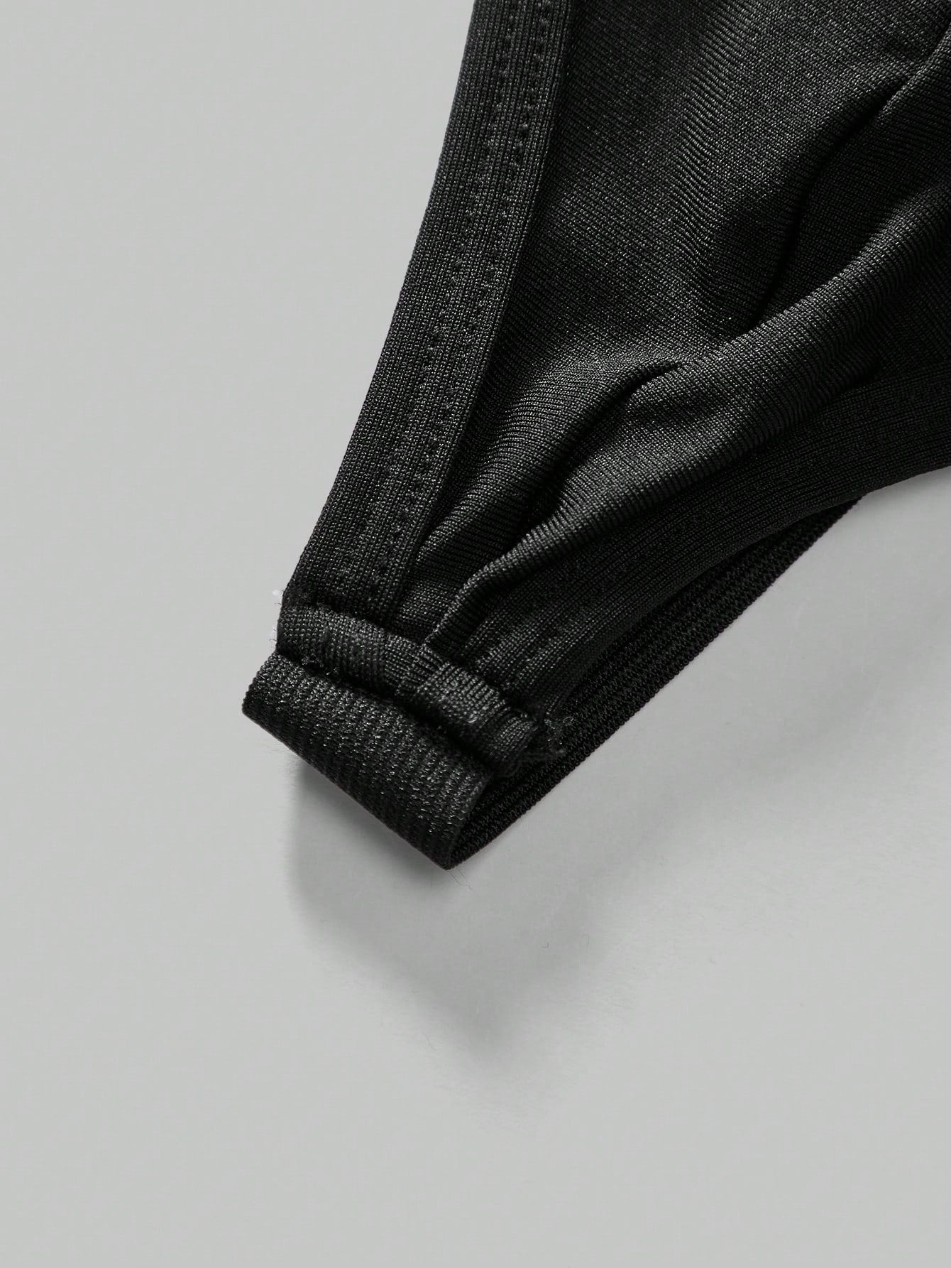 Men's black low-rise thong underwear with a plain solid color design
