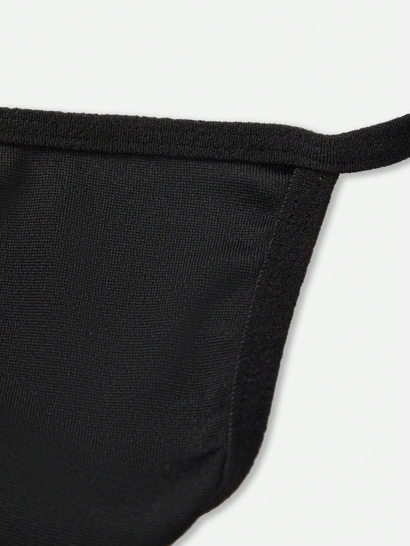 Men's black low-rise minimalist thong underwear with silver bead detail at the back