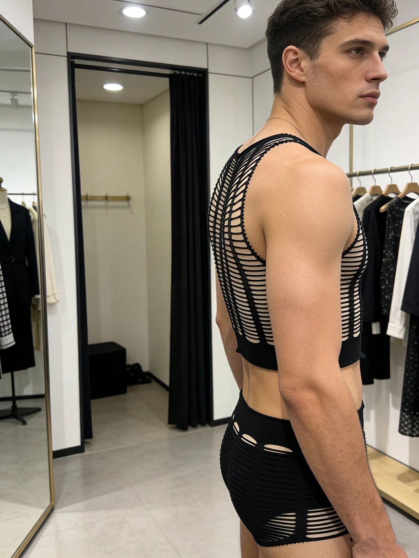 Men's black sheer fishnet 2-piece lingerie set with a round-neck short top and mid-rise thong-style boyshorts featuring a striped hollow-out knit design.