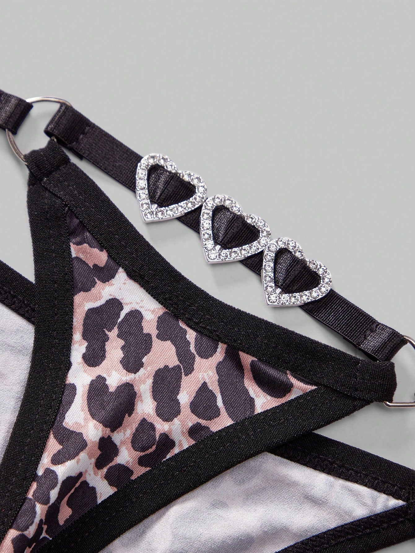 Men's multicolor thong underwear with leopard print, rhinestone heart decor, ring detail, low-rise fit, and sheer knitted fabric.