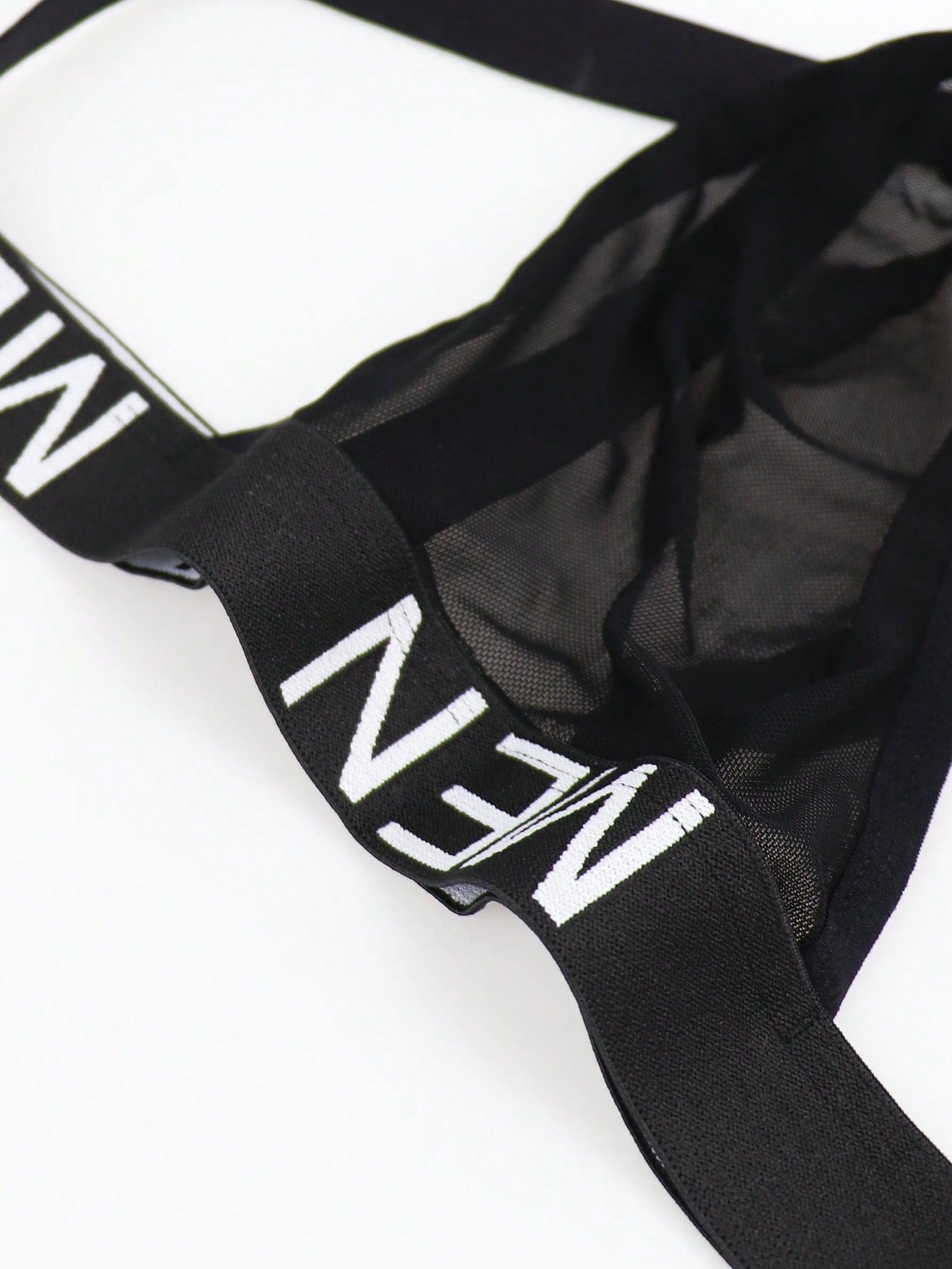 Men's black low-rise jockstrap briefs made from striped mesh fabric with a slim fit design