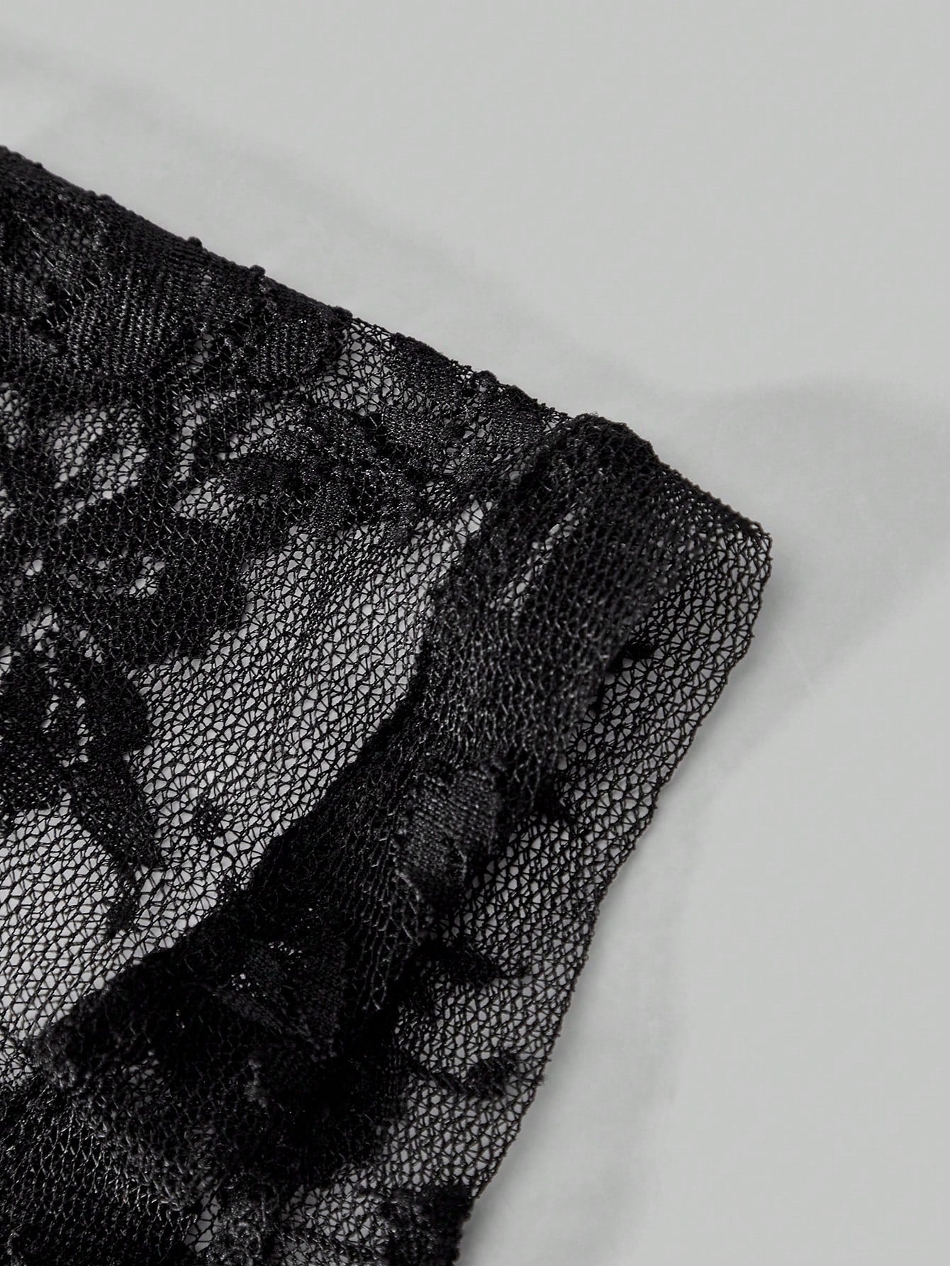 Men's black and white lace trim briefs with tape details and letter and plant pattern, shown as a short regular-fit underwear style.