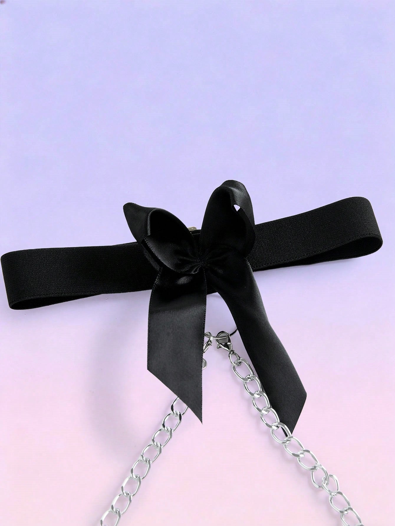 Black men's mid-rise briefs with letter woven strap, backless knot and tape details, and chain necklace
