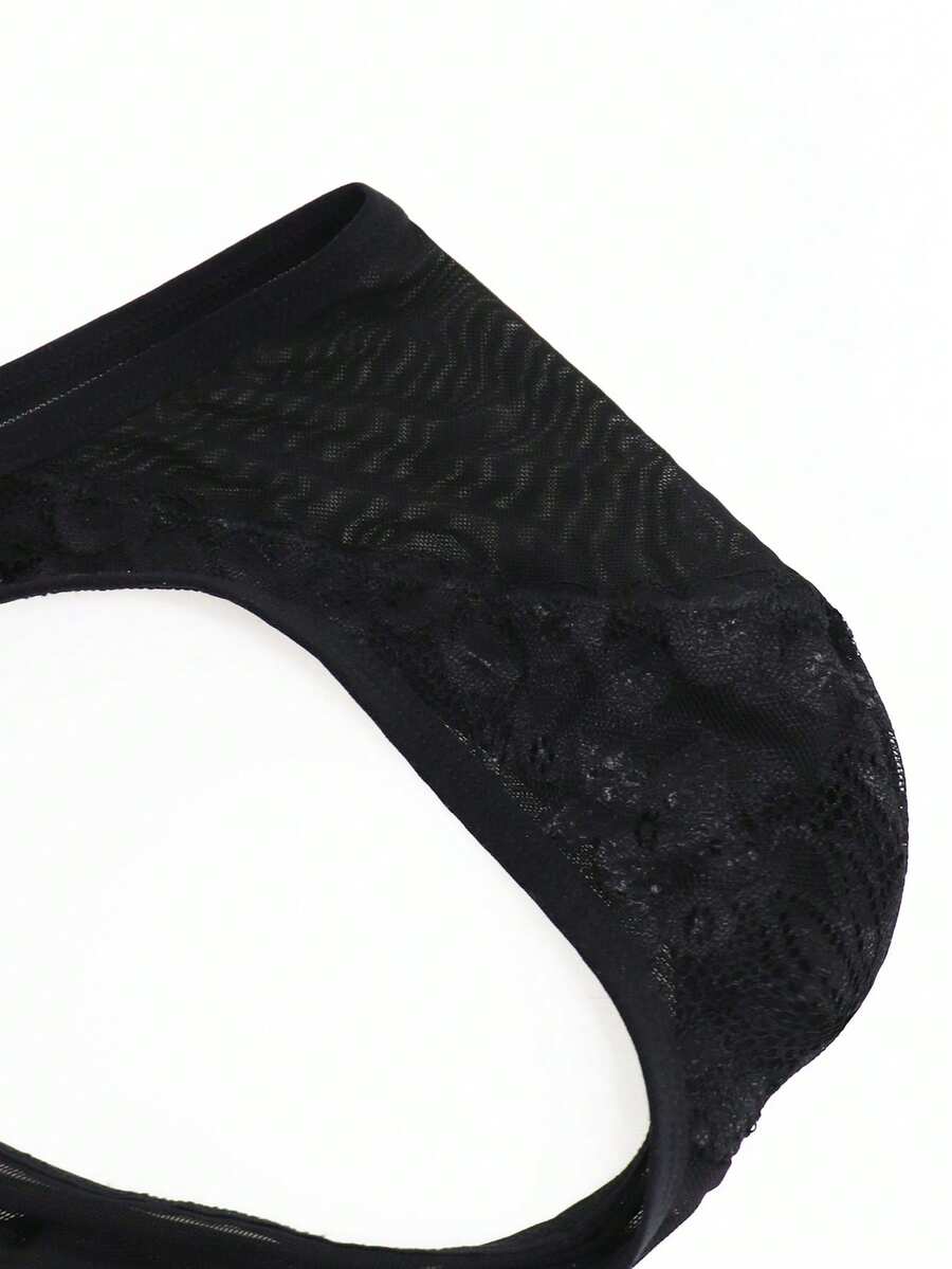 Black mid-rise mesh briefs for men featuring a hollow lace design and colorblock pattern.