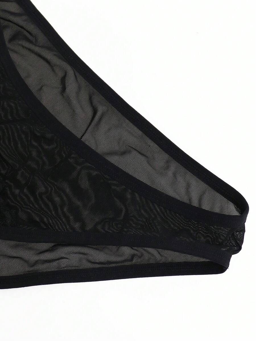 Black mid-rise mesh briefs for men featuring a hollow lace design and colorblock pattern.