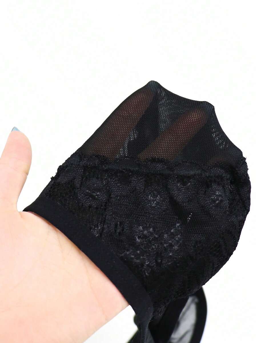 Black mid-rise mesh briefs for men featuring a hollow lace design and colorblock pattern.