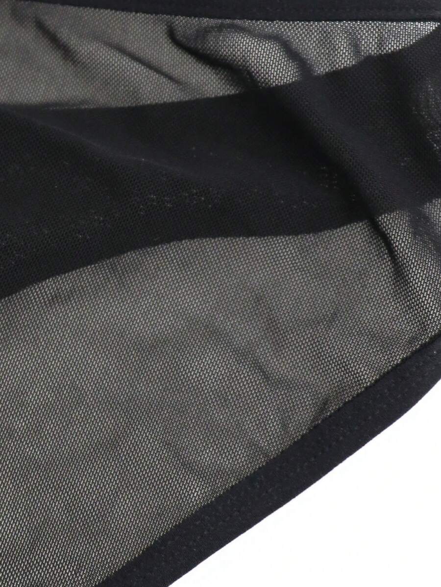 Black mid-rise mesh briefs for men featuring a hollow lace design and colorblock pattern.