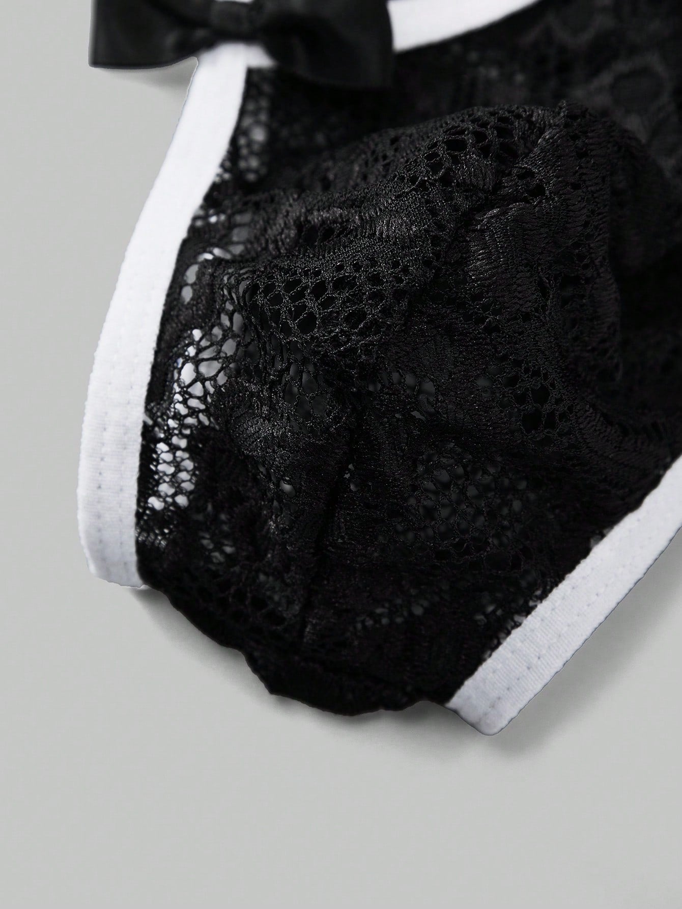 Men's black lace thong underwear with sheer details and bowknot ribbon accent, low-rise semi-sheer design