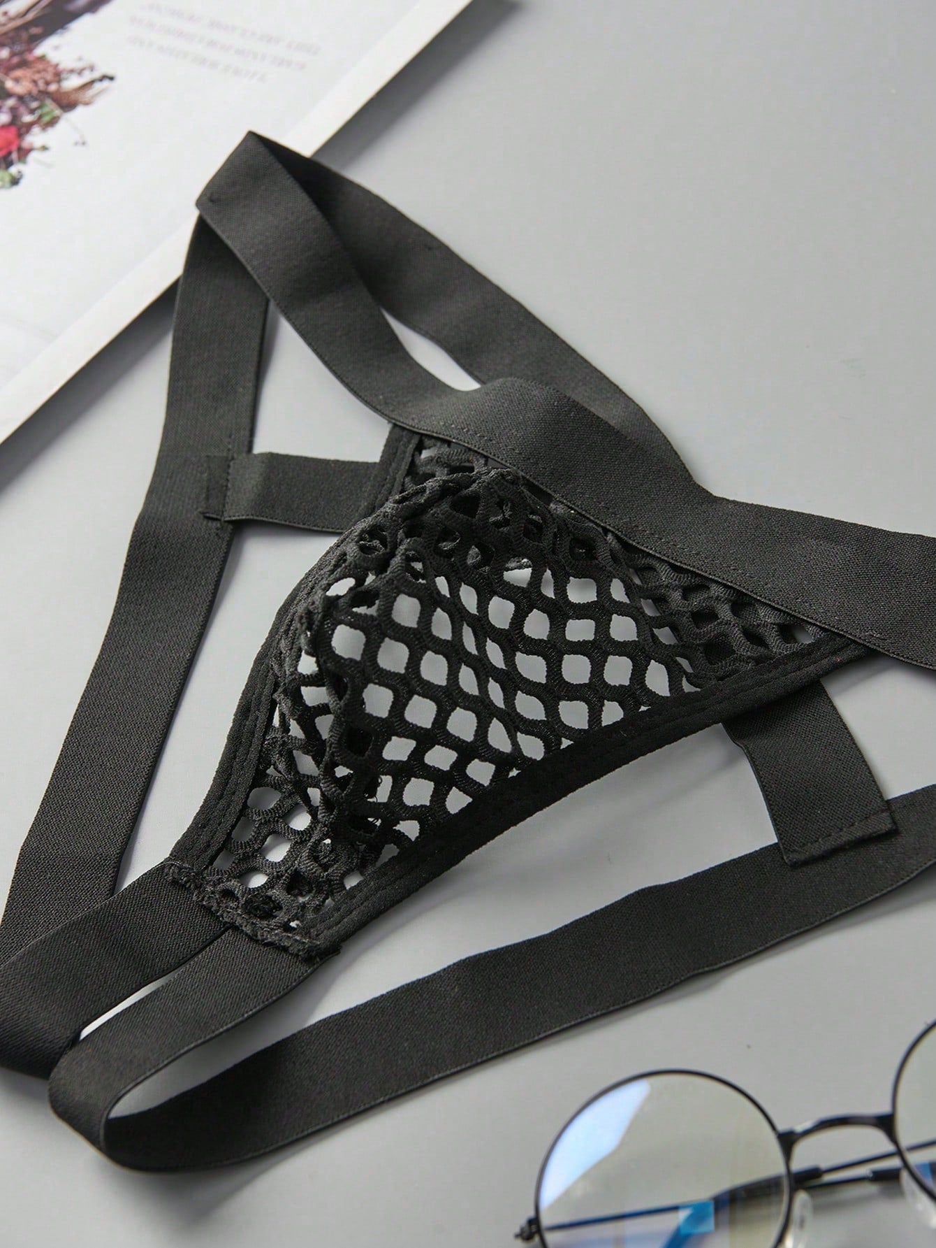 Men's black semi-sheer mesh double thong jockstrap with criss cross straps, cut out details, low rise fit, and geometric pattern.