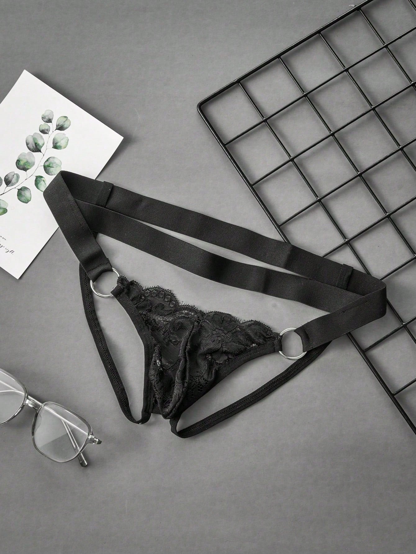 Men's black lace low-rise jockstrap thong with contrast lace, hollow-out details, and semi-sheer plain design