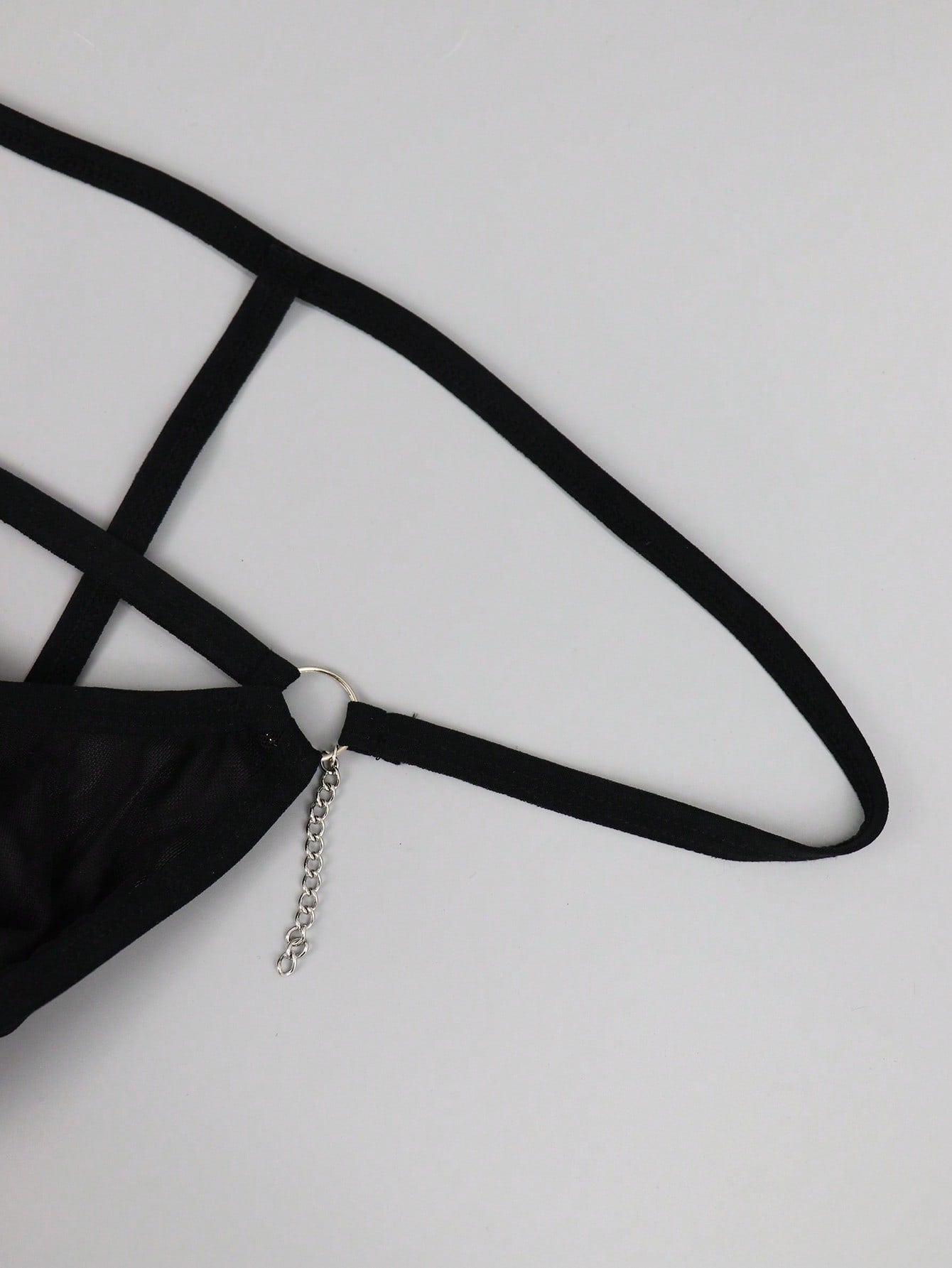 Men's black mesh low-rise thong with colorblock design and chain accessory detail