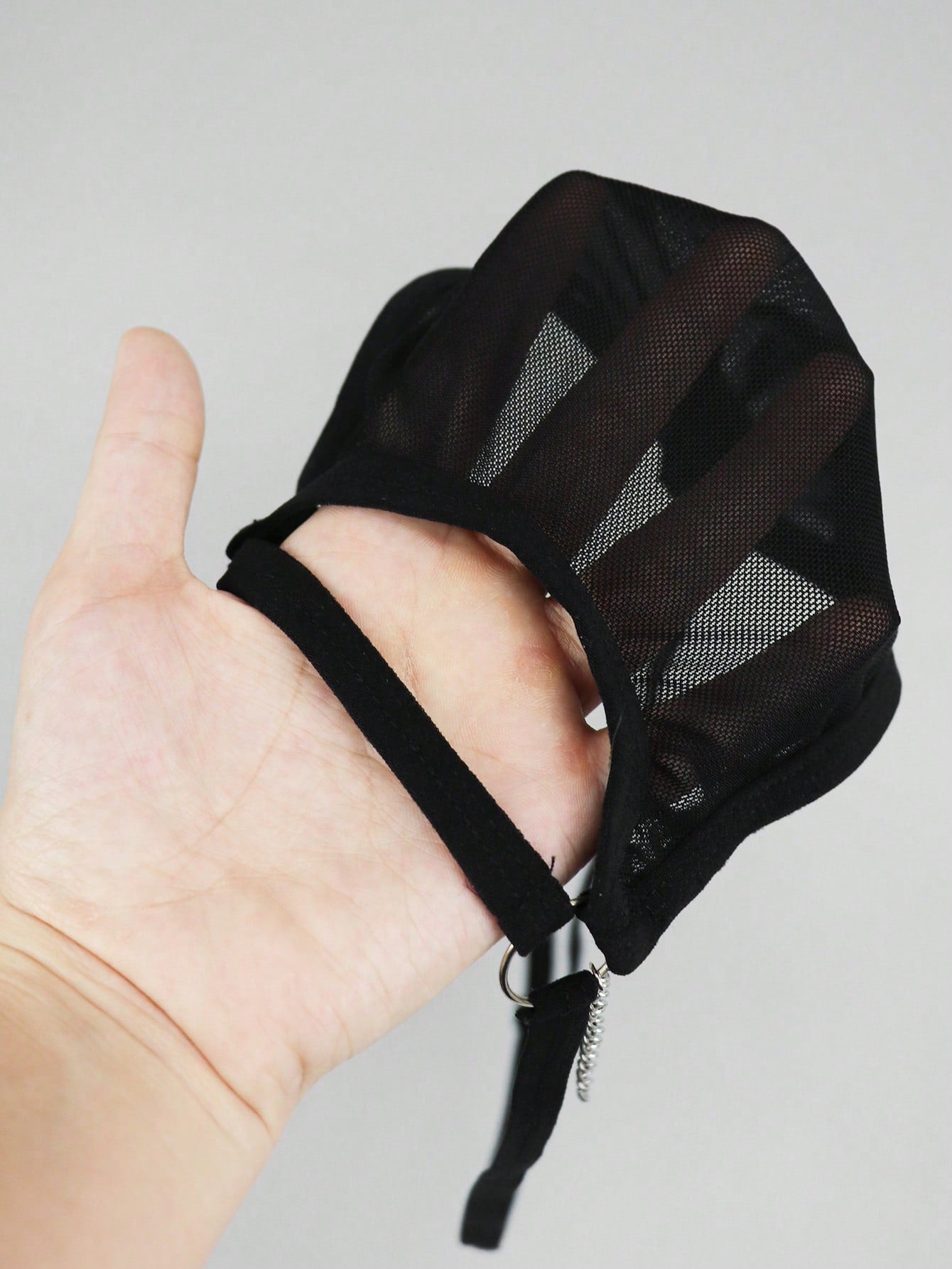 Men's black mesh low-rise thong with colorblock design and chain accessory detail