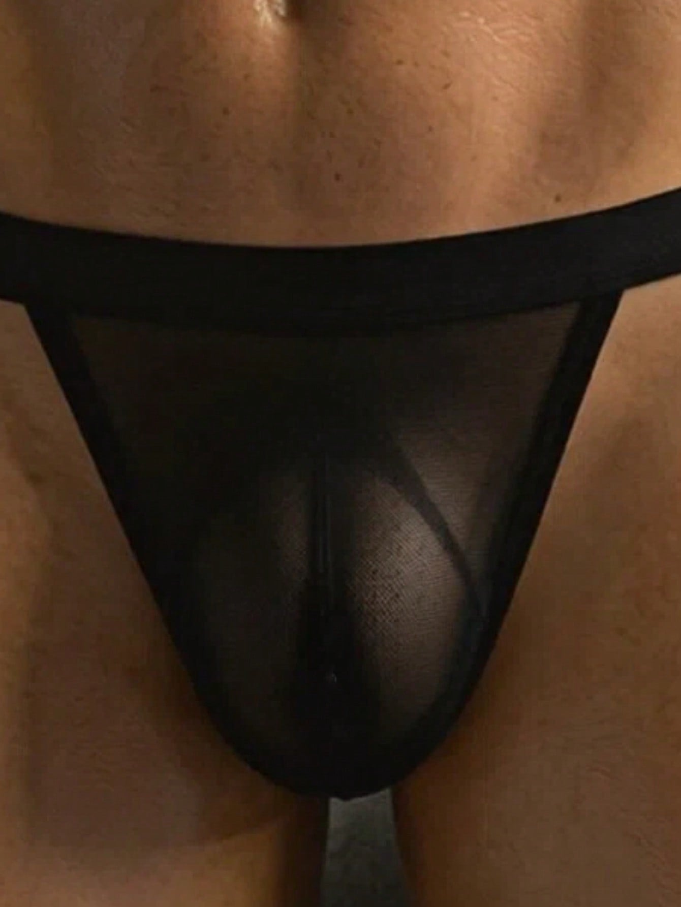 Men's black hollow mesh thong underwear with a scoop neckline, mid-rise fit, and colorblock design