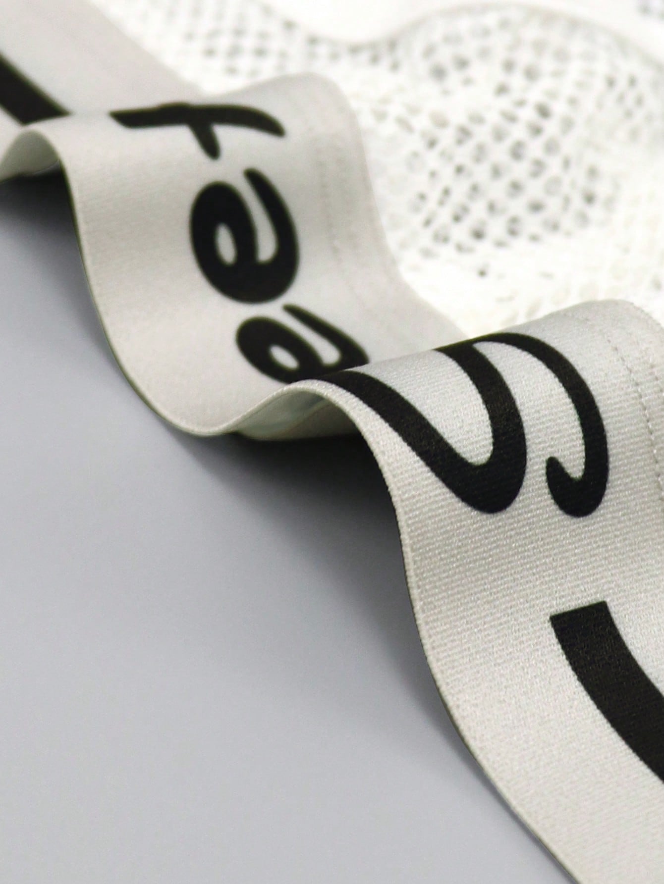 Men's contrast letter print mesh briefs with low-rise cut, tape detail, and contrast binding