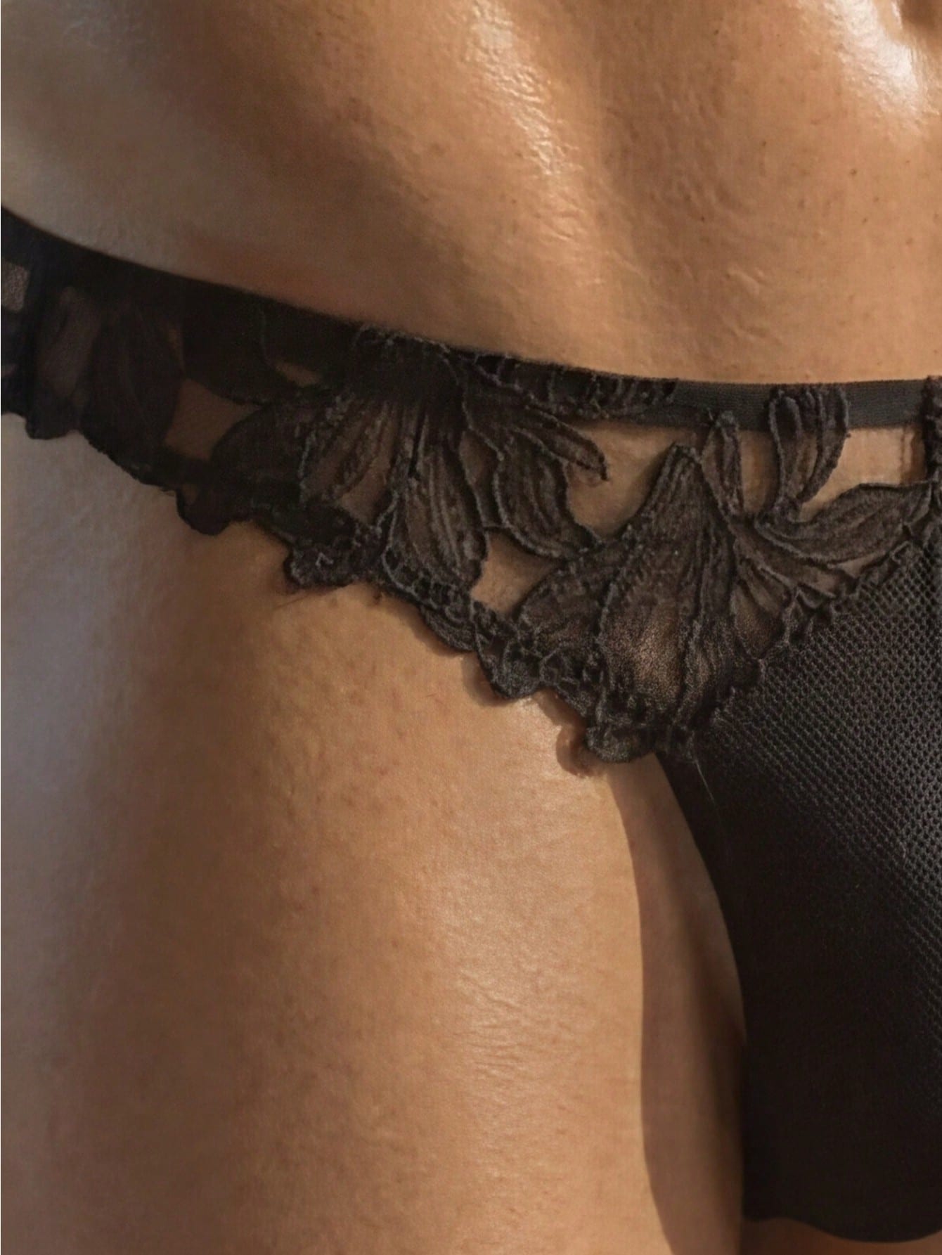 Men's black costume underwear with lace patchwork styling, short length, and regular fit