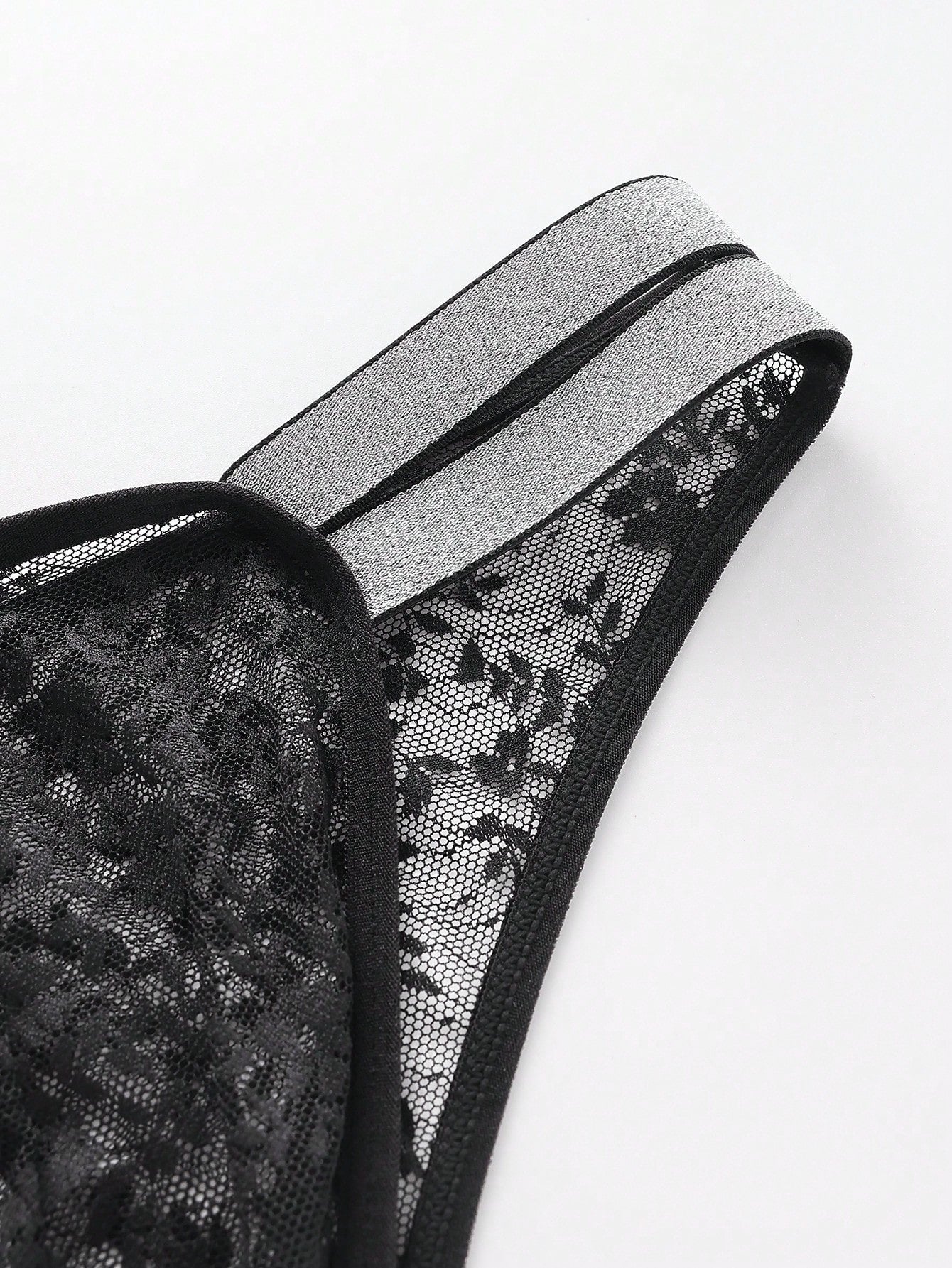 Men's black semi-sheer lace low-rise thong briefs with colorblock styling