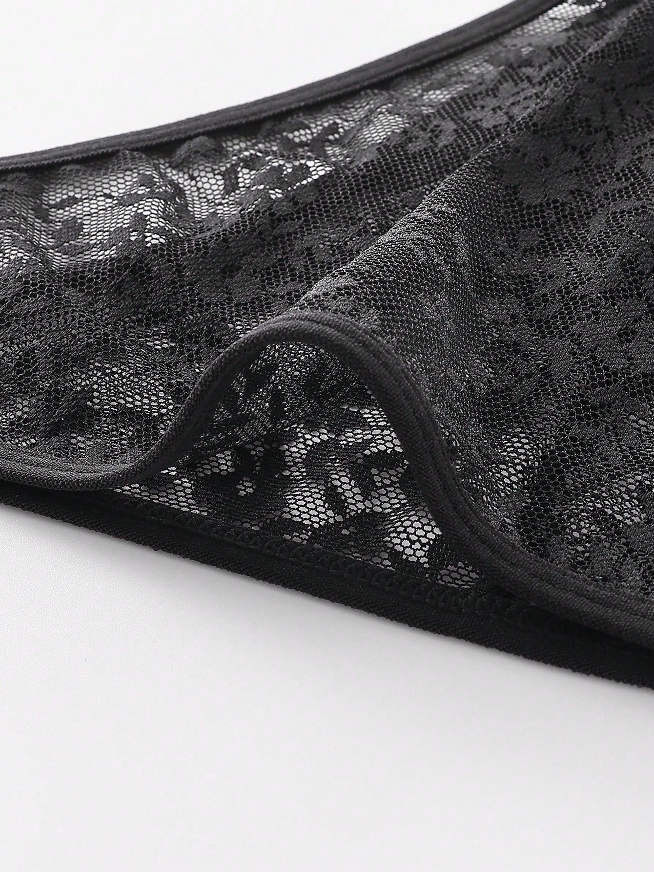 Men's black semi-sheer lace low-rise thong briefs with colorblock styling
