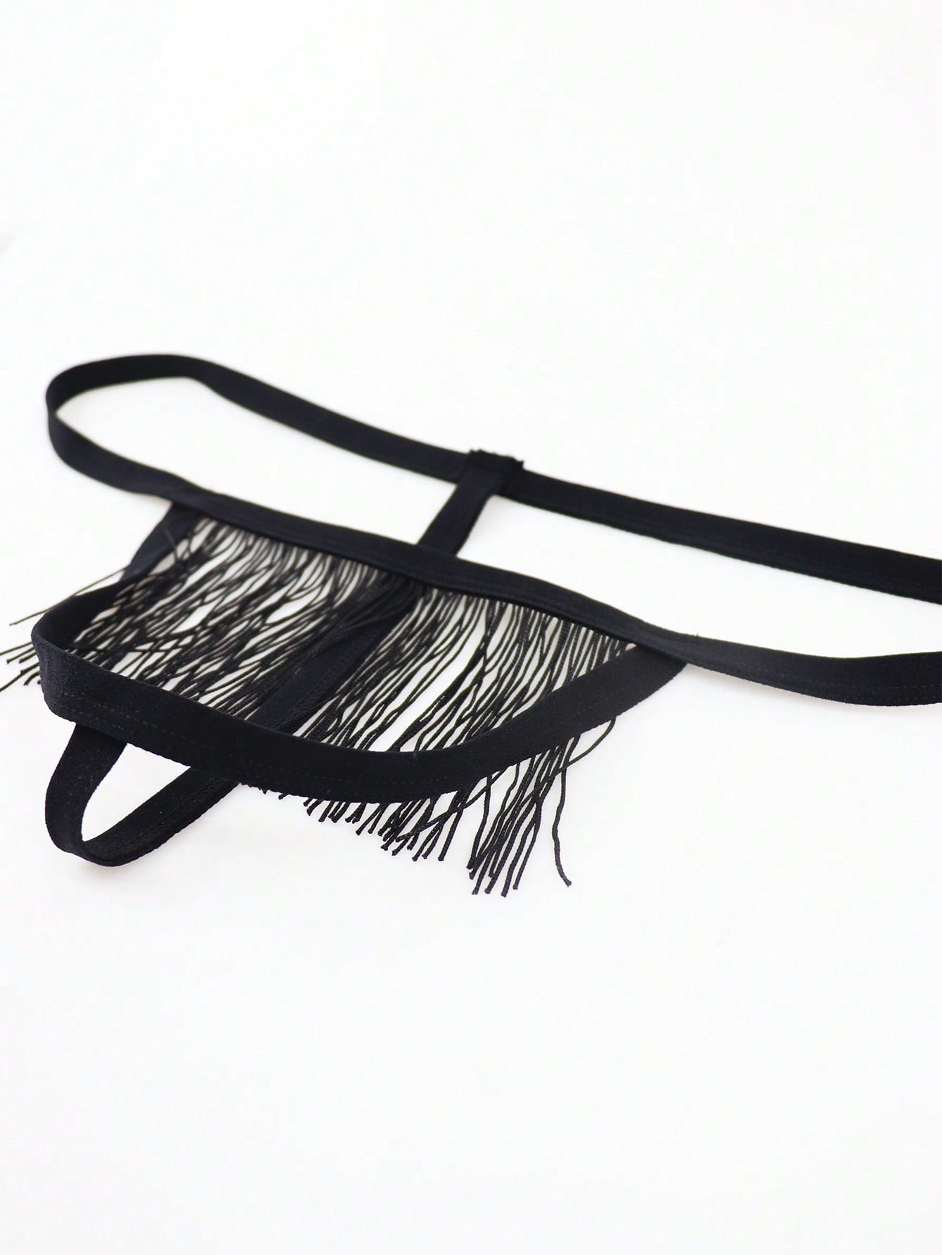 Men's black mid-rise thong underwear with fringe detail, plain design, and medium-stretch knitted fabric.