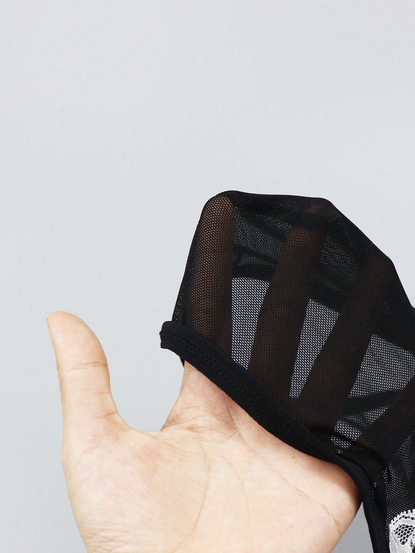 Men's black and white colorblock mid-rise thong made from mesh fabric with lace detailing
