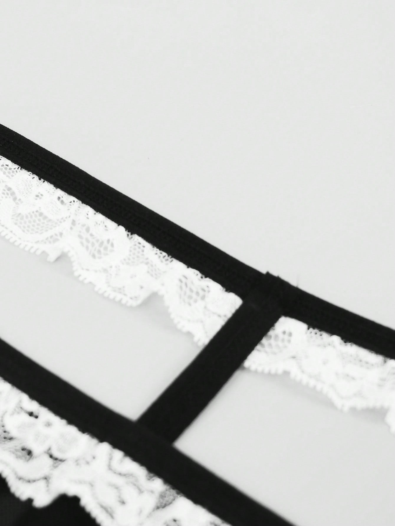 Men's black and white colorblock mid-rise thong made from mesh fabric with lace detailing