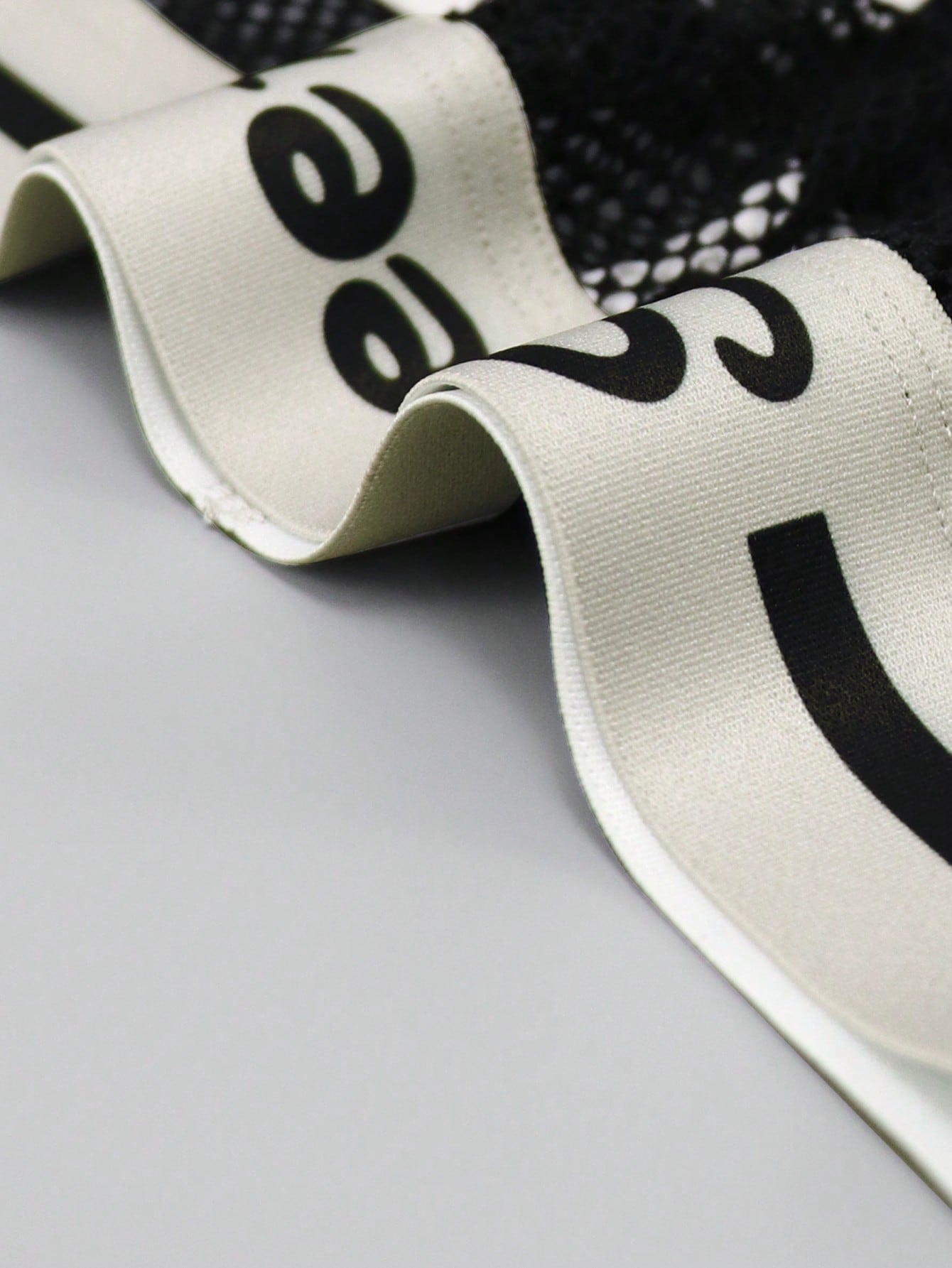 Men's contrast letter print mesh briefs with low-rise cut, tape detail, and contrast binding