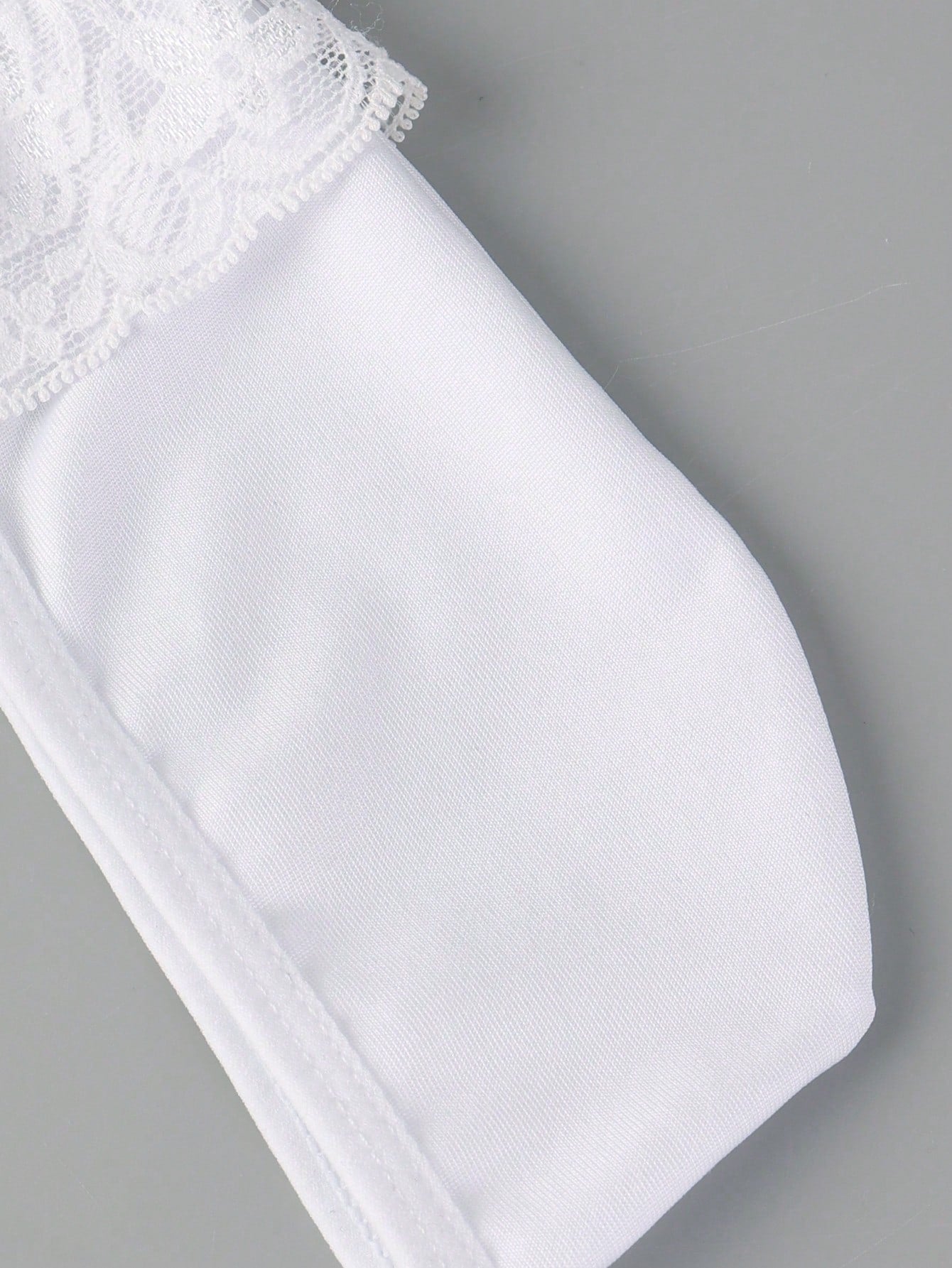 Men's white low-rise thong underwear with contrast lace detail and mesh fabric