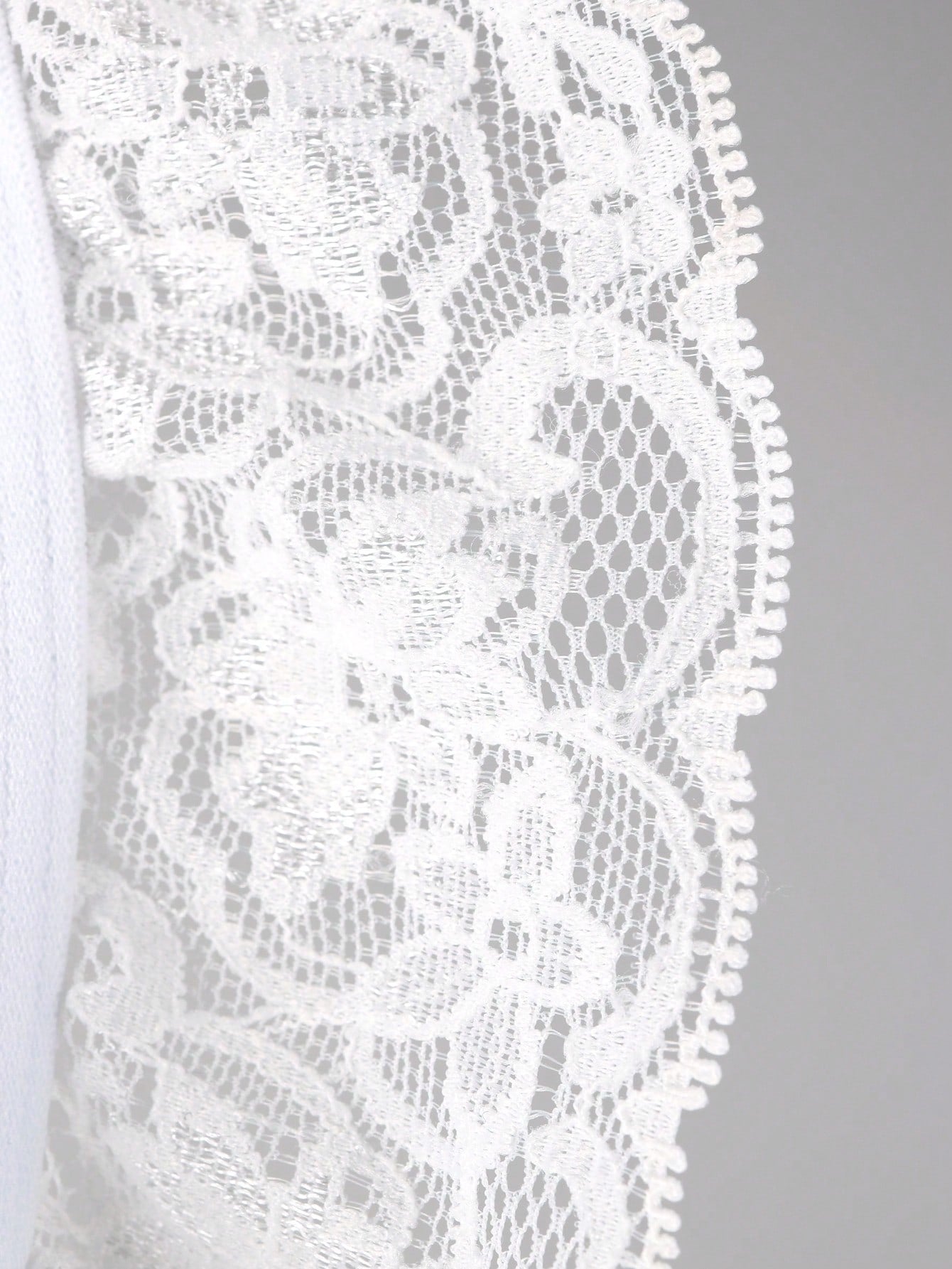 Men's white low-rise thong underwear with contrast lace detail and mesh fabric
