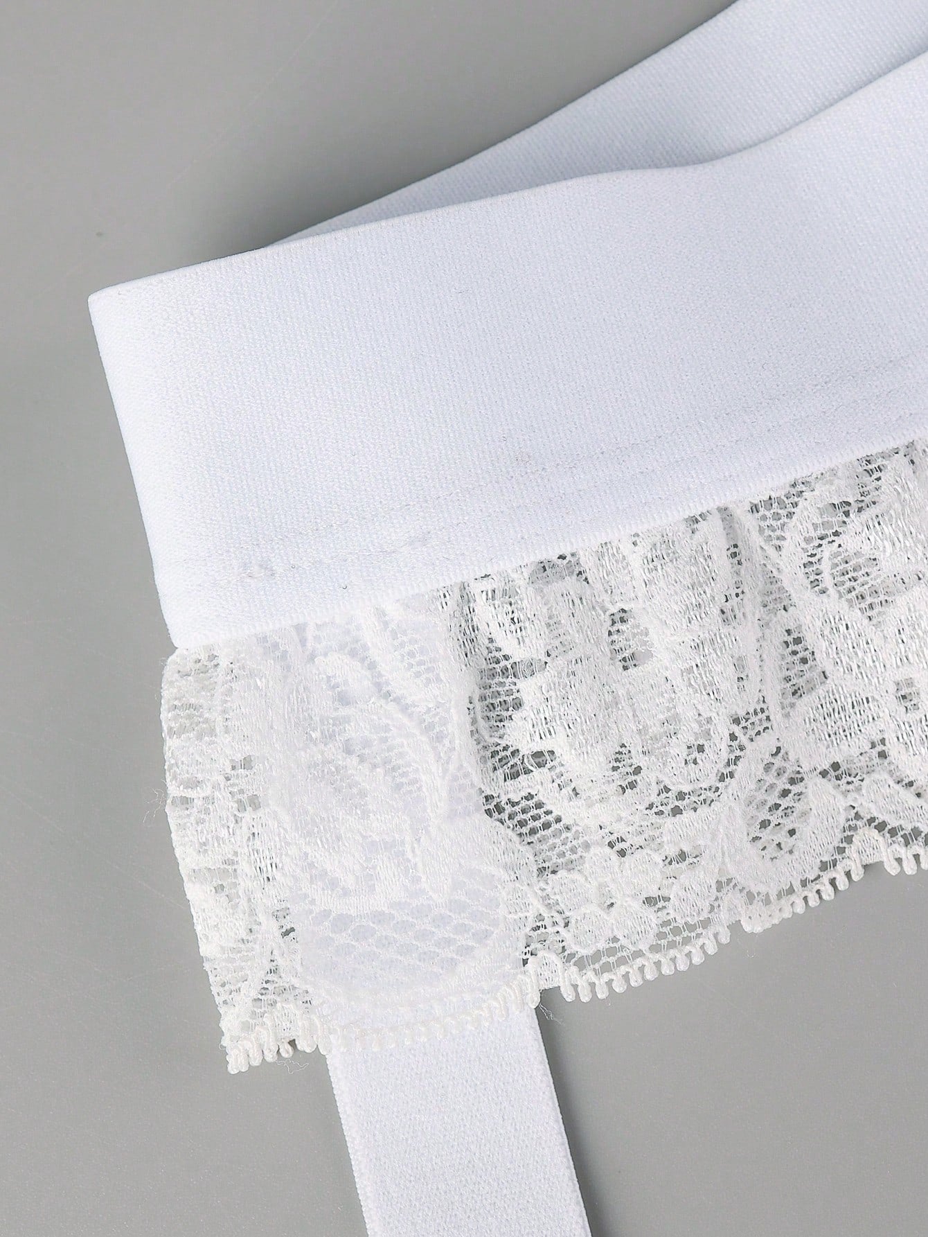 Men's white low-rise thong underwear with contrast lace detail and mesh fabric