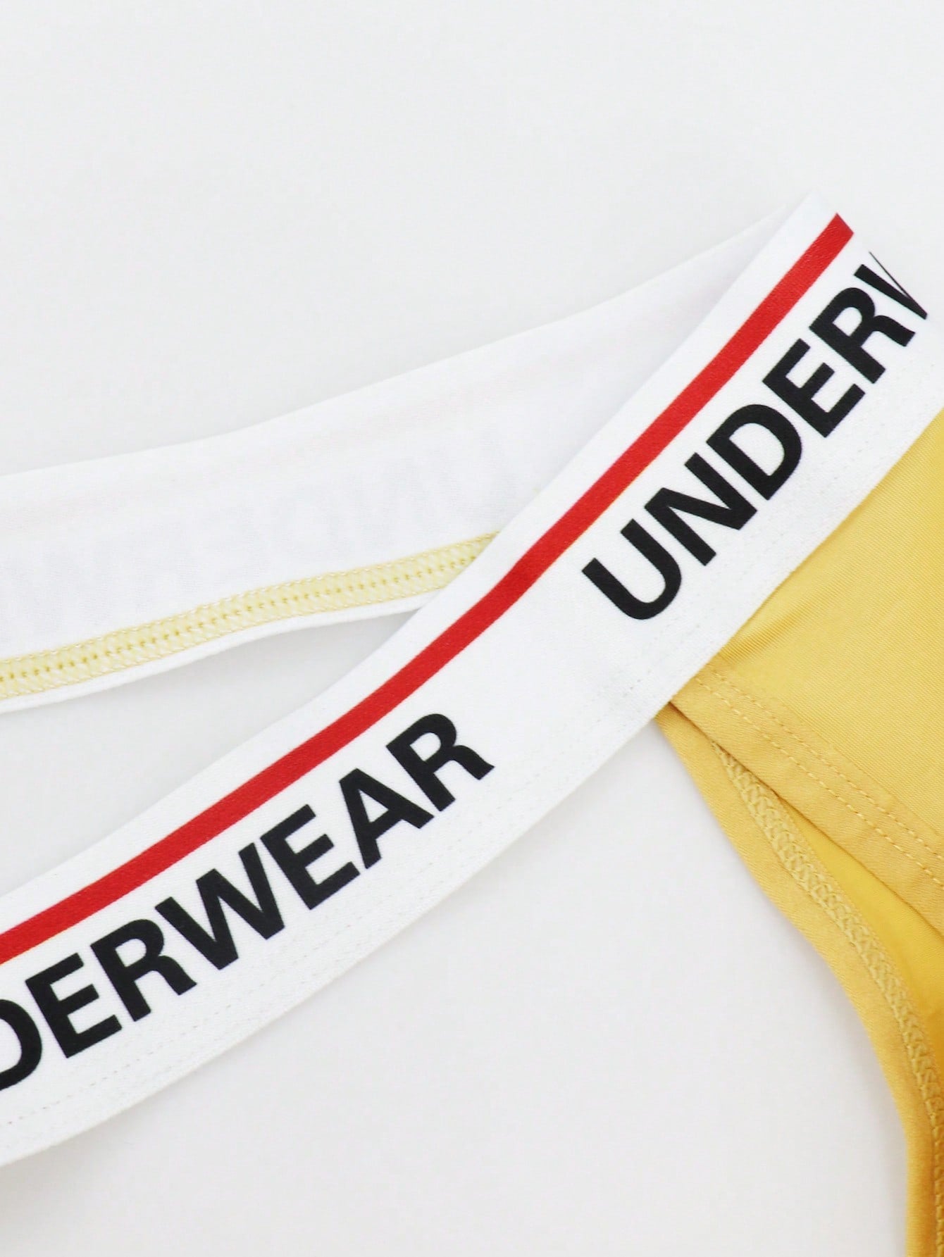 Men's low-rise thong briefs with letter waistband trim and rhinestone detail